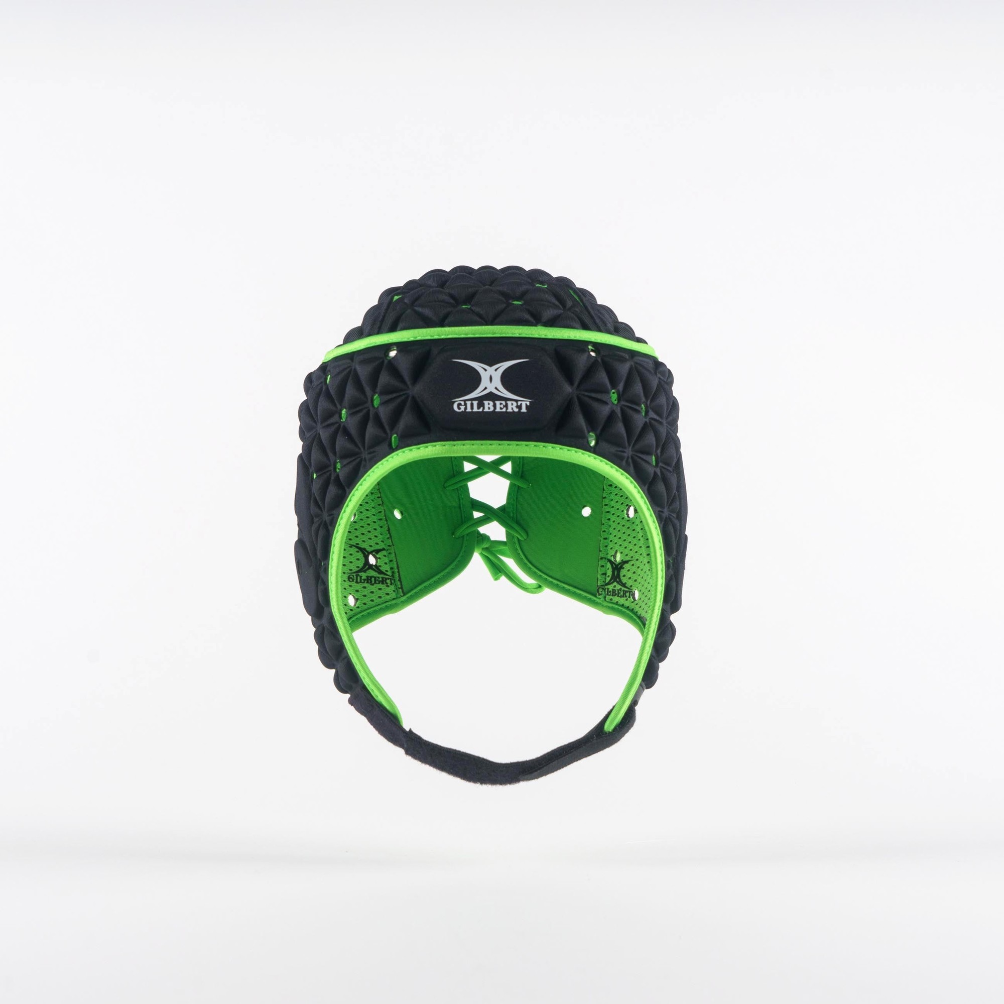 Black junior headguard by Gilbert Rugby featuring a padded design with green accents, adjustable chin strap, and ventilation holes for comfort and protection during rugby.