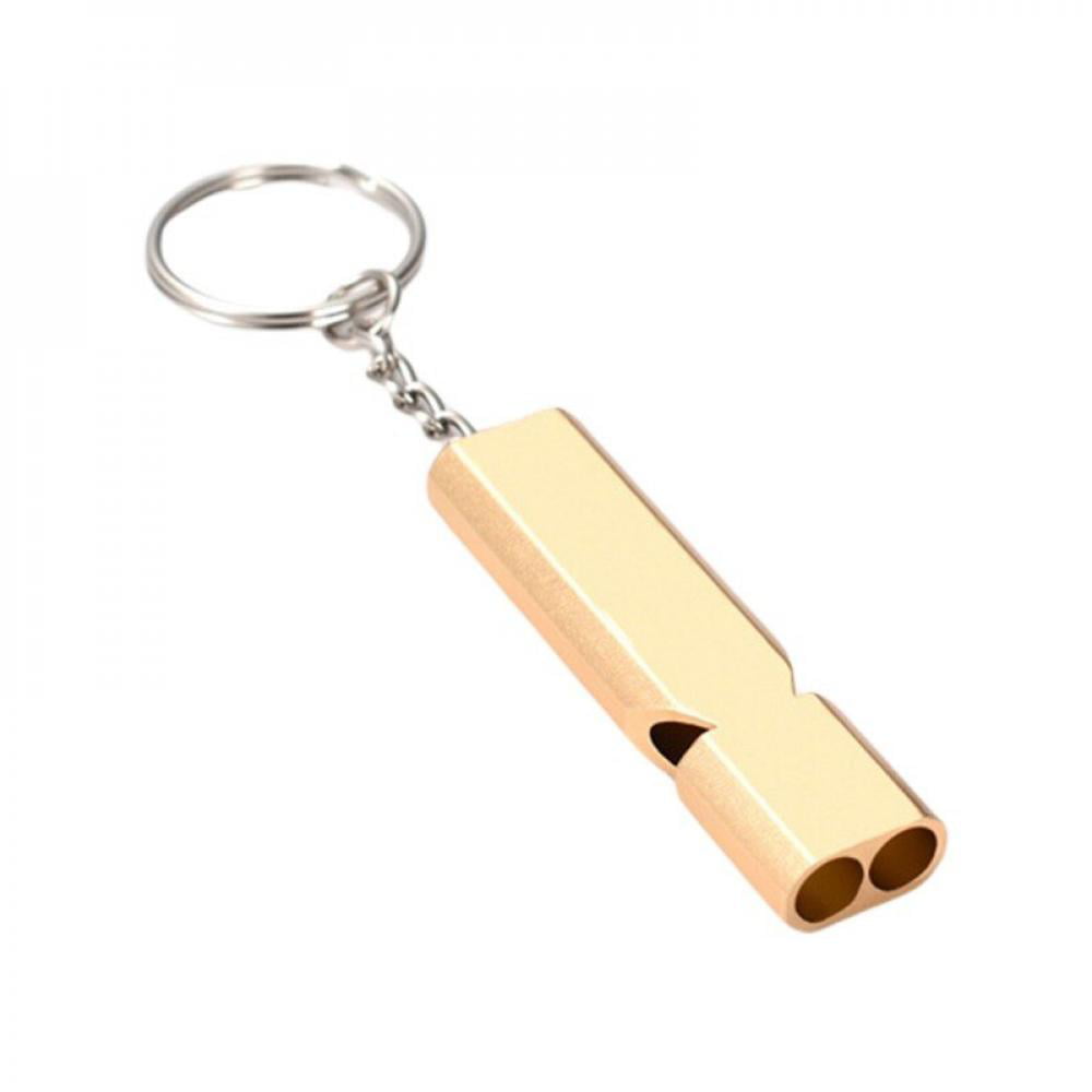 Gold-colored metal whistle keychain with a sleek design, featuring two openings at the end and attached to a silver keyring.