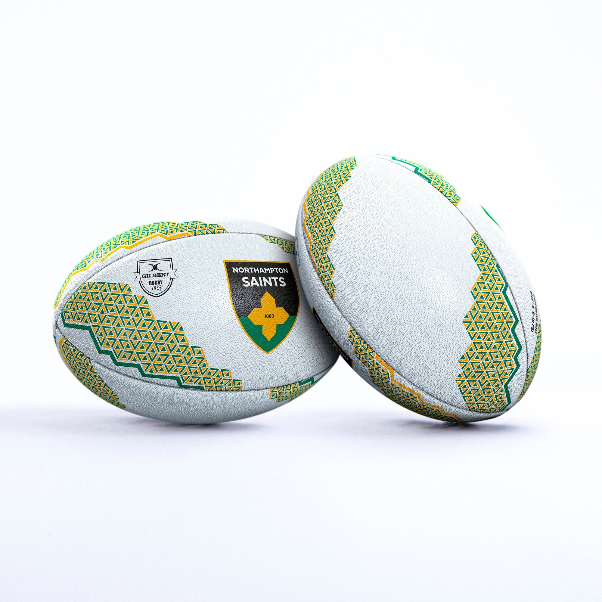 White rugby ball featuring green and yellow geometric patterns, with the Northampton Saints logo prominently displayed, made from durable synthetic material.