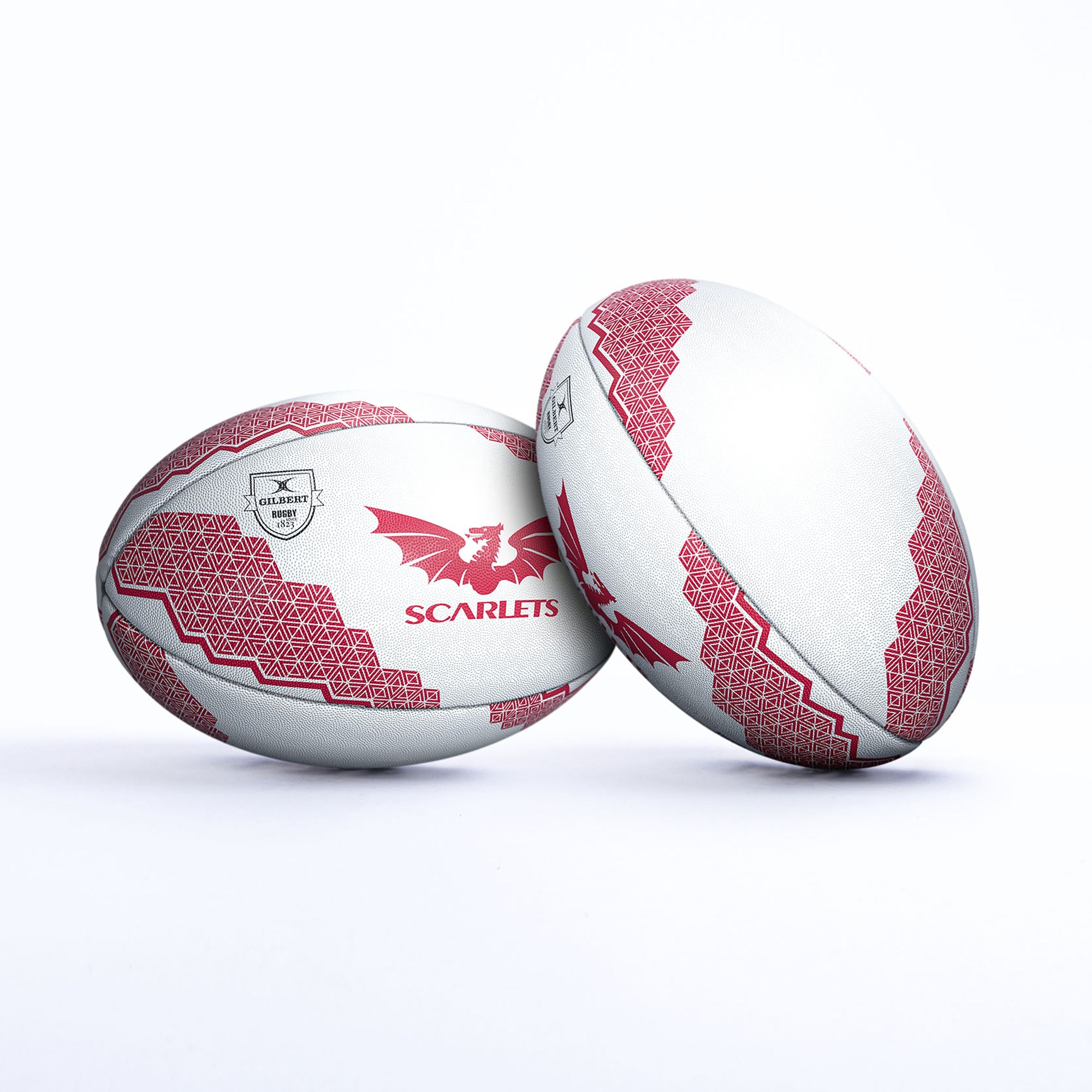 White rugby ball featuring red geometric patterns and a dragon logo, prominently displaying "SCARLETS" on its surface, made from durable material for support and play.