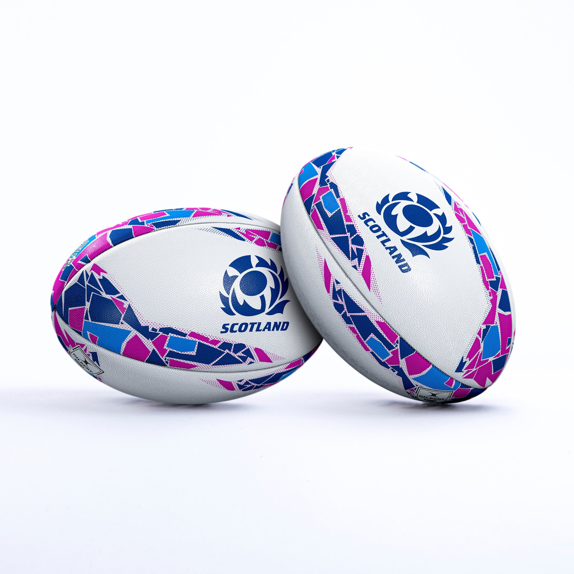White rugby ball featuring a vibrant blue and pink geometric design, with "SCOTLAND" and the Scottish Rugby emblem prominently displayed.