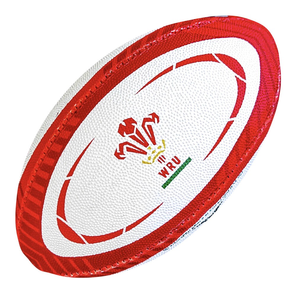 White rugby ball with red accents, featuring the Welsh dragon emblem and "WRU" logo, designed for replica play in durable synthetic material.