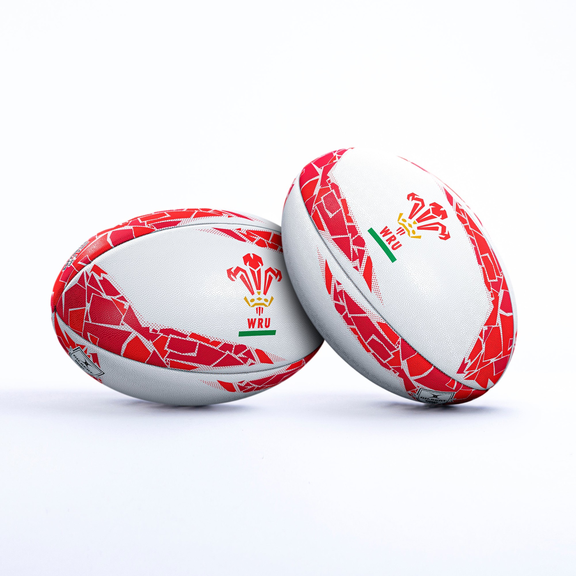 White rugby ball featuring red and green accents, adorned with the Welsh dragon emblem and "WRU" logo, designed for supporters of Wales, made from durable synthetic material.