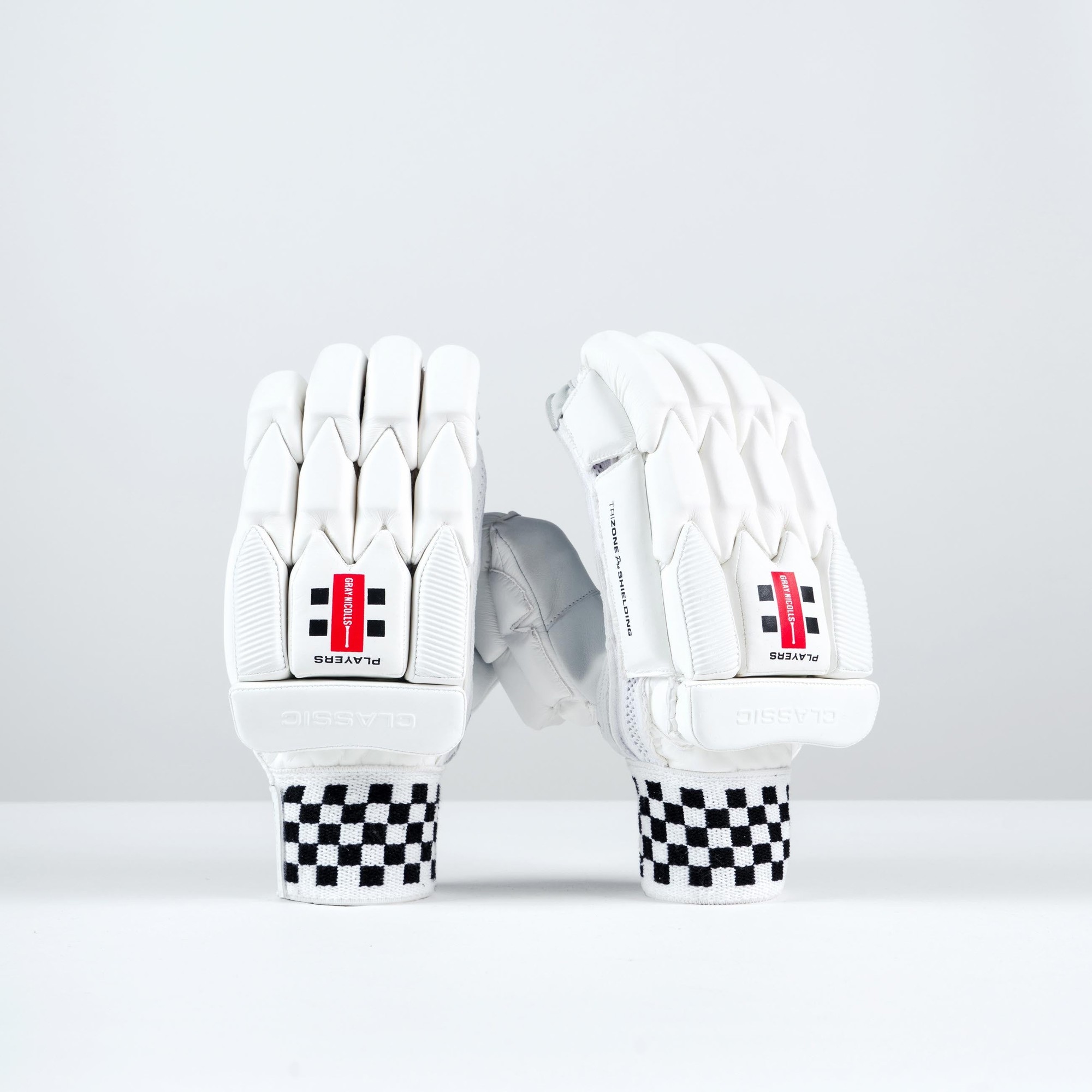 Gray-Nicolls Classic Players batting gloves in white, featuring padded fingers, a textured palm for grip, and a black and white checkered wristband.
