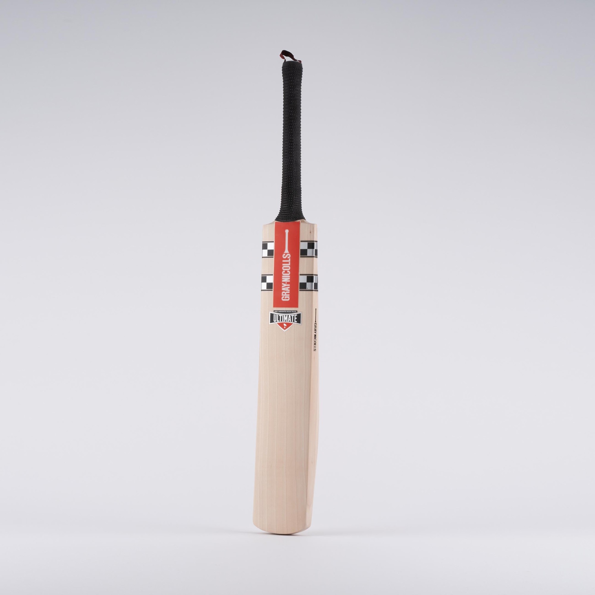 Gray-Nicolls Classic Ultimate Junior Cricket Bat in black and white, featuring a smooth wooden blade, a textured black grip, and a distinctive red and white label.