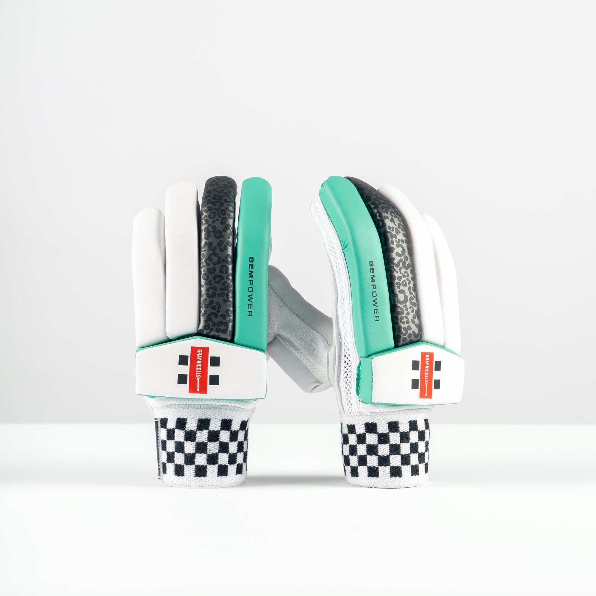 Gray-Nicolls GEM 3.1 Power women's batting gloves in white with green and black accents, featuring a textured grip and a checkered pattern on the wrist.