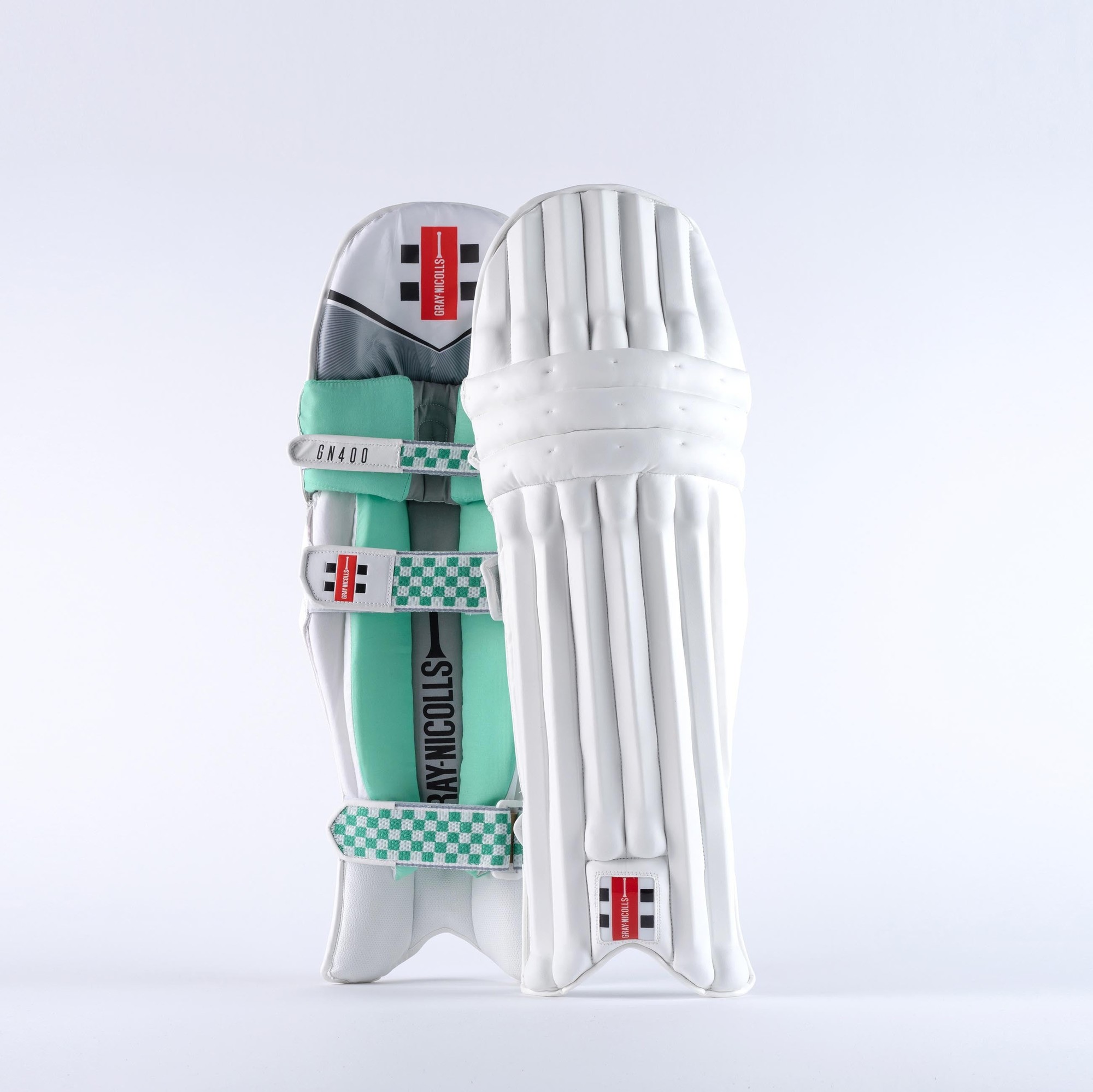 Gray-Nicolls GEM GN400 cricket pads in white with green accents, featuring a sleek design, padded protection, and adjustable straps for a secure fit.