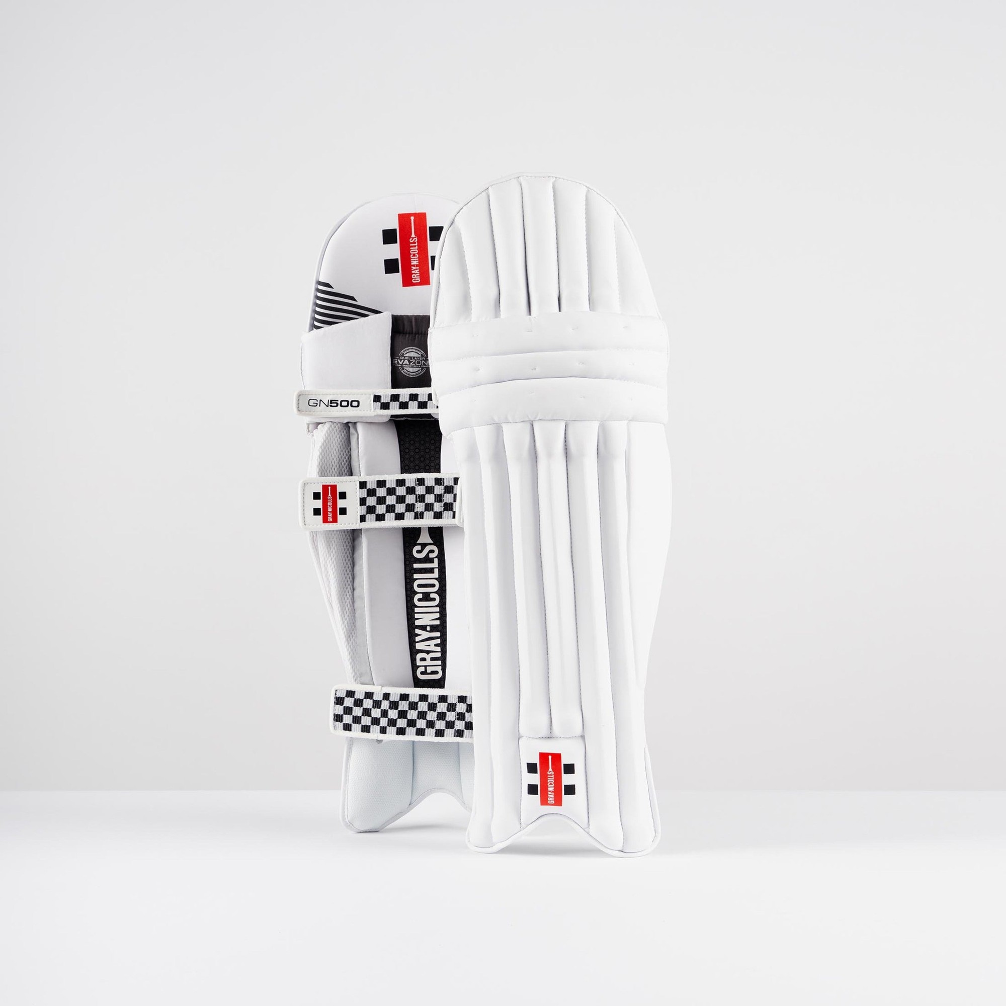 White Gray-Nicolls GN500X batting pads featuring a sleek design, padded protection, and adjustable straps, with black and red accents for a modern look.