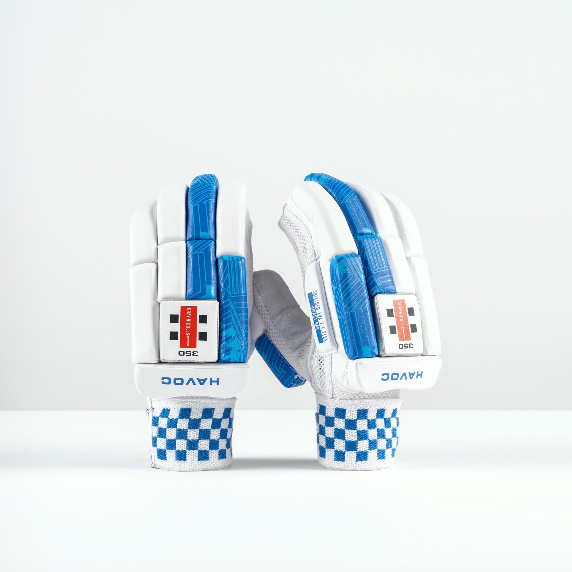 White Gray-Nicolls Havoc 1.0 350 junior batting gloves featuring blue accents, textured grip, and a checkered wrist strap for enhanced support and comfort.