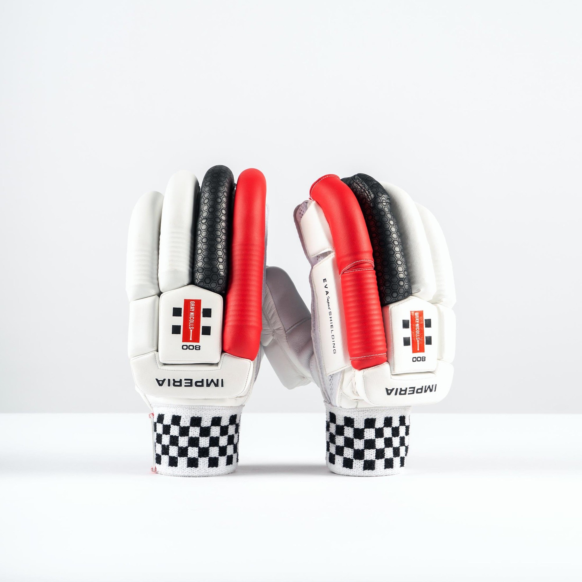 White batting gloves with red and black accents, featuring a textured grip, padded protection, and a checkered wrist strap, labeled "IMPERIA 800."