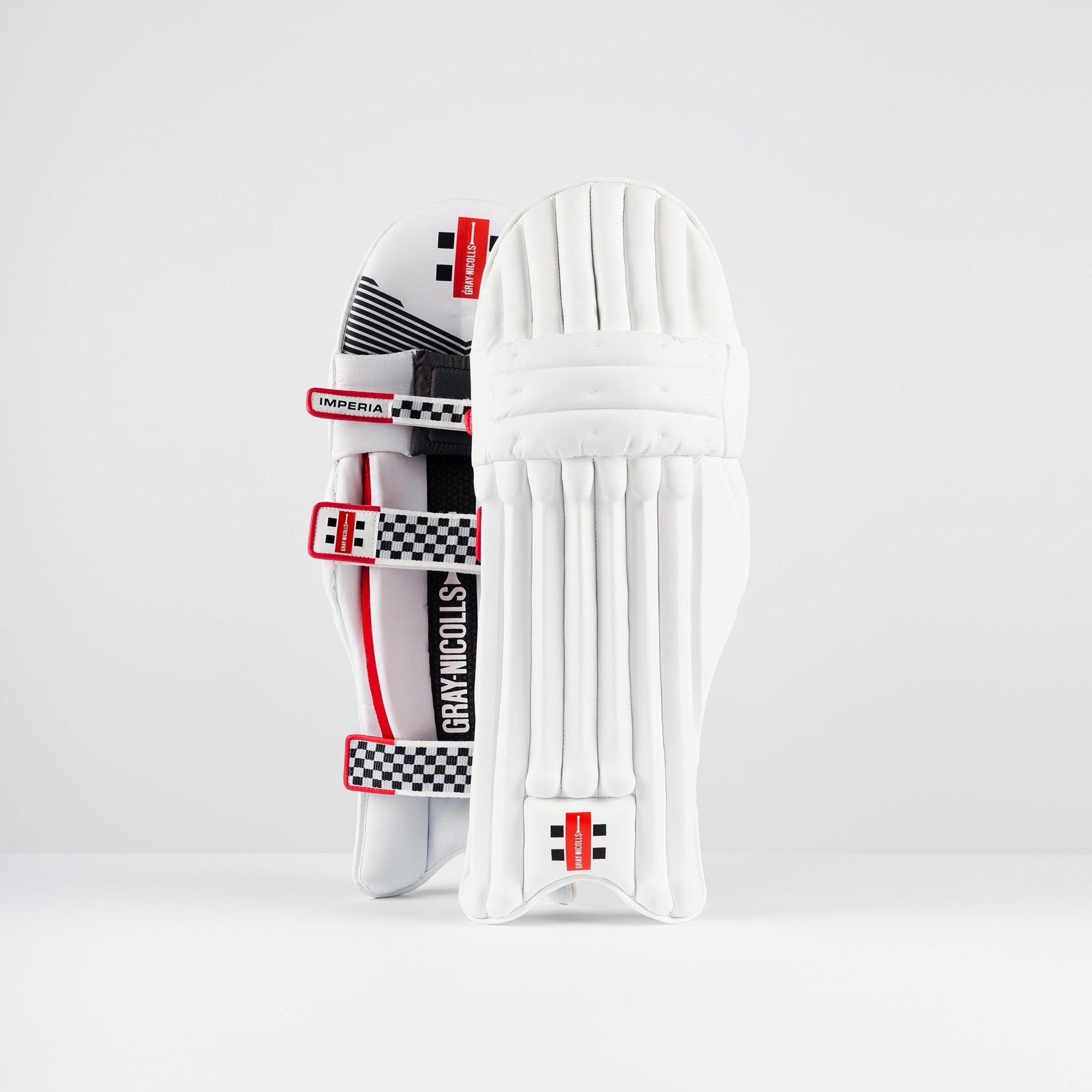 White Gray-Nicolls Imperia 1.0 batting pads featuring a sleek design, padded protection, and red accents with adjustable straps for a secure fit.
