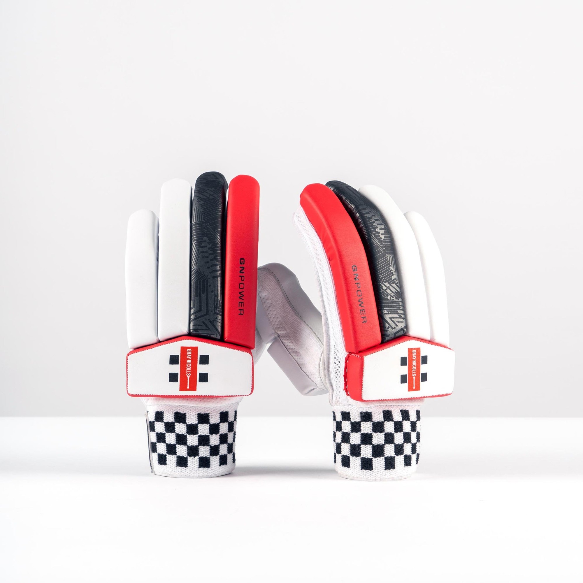 Gray-Nicolls PowerX adult batting gloves in white with red accents, featuring a textured grip, padded protection, and a distinctive checkered wrist strap.