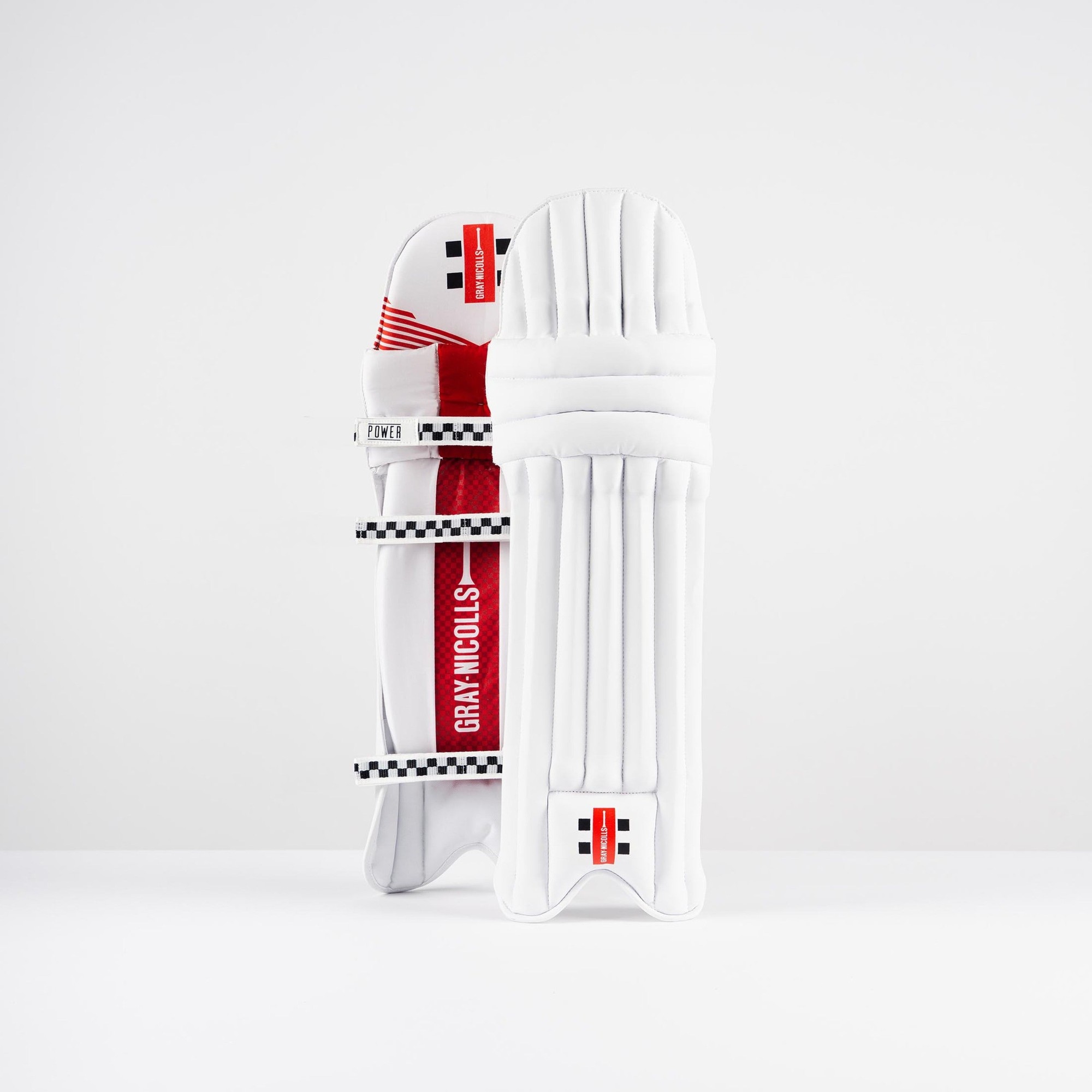 Gray-Nicolls PowerX batting pads in white with red accents, featuring a durable design, cushioned protection, and adjustable straps for a secure fit.