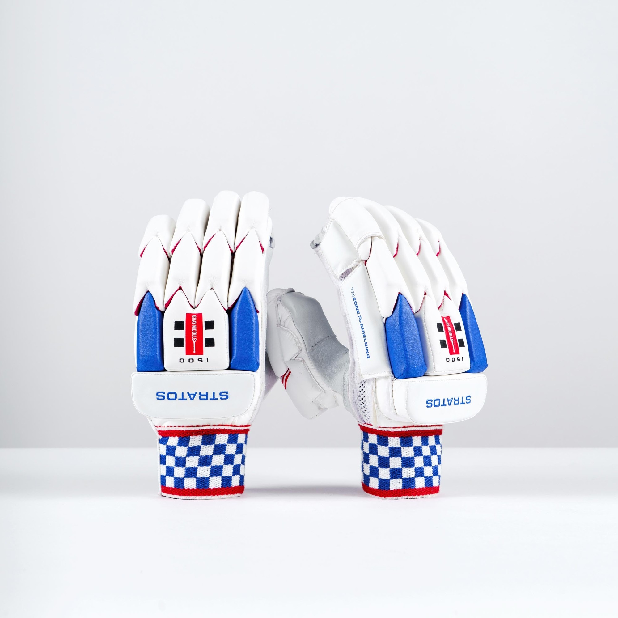 White Gray-Nicolls Stratos 1.0 1500 batting gloves featuring red and blue accents, a padded design, and a checkered wrist strap for enhanced grip and protection.