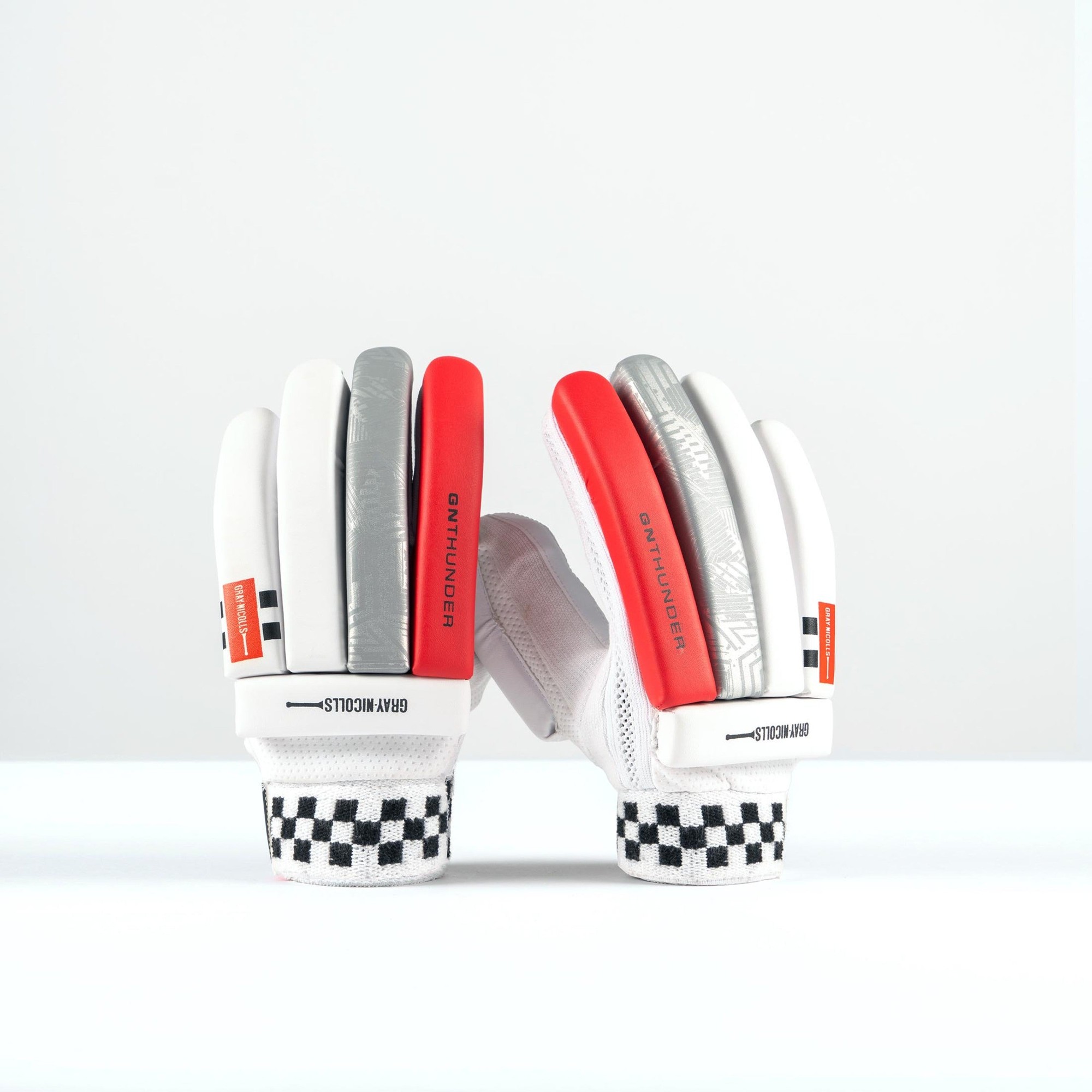 Gray-Nicolls Thunder Junior Batting Gloves in white with gray and red accents, featuring a textured palm, mesh backing, and a checkered wrist strap for added support.