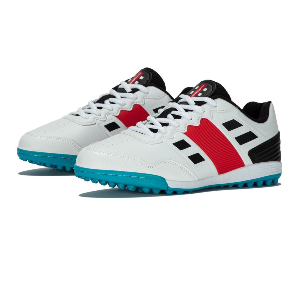 White rubber adult shoes featuring a red and black design, with a textured sole for traction, and a sleek, sporty look ideal for cricket.