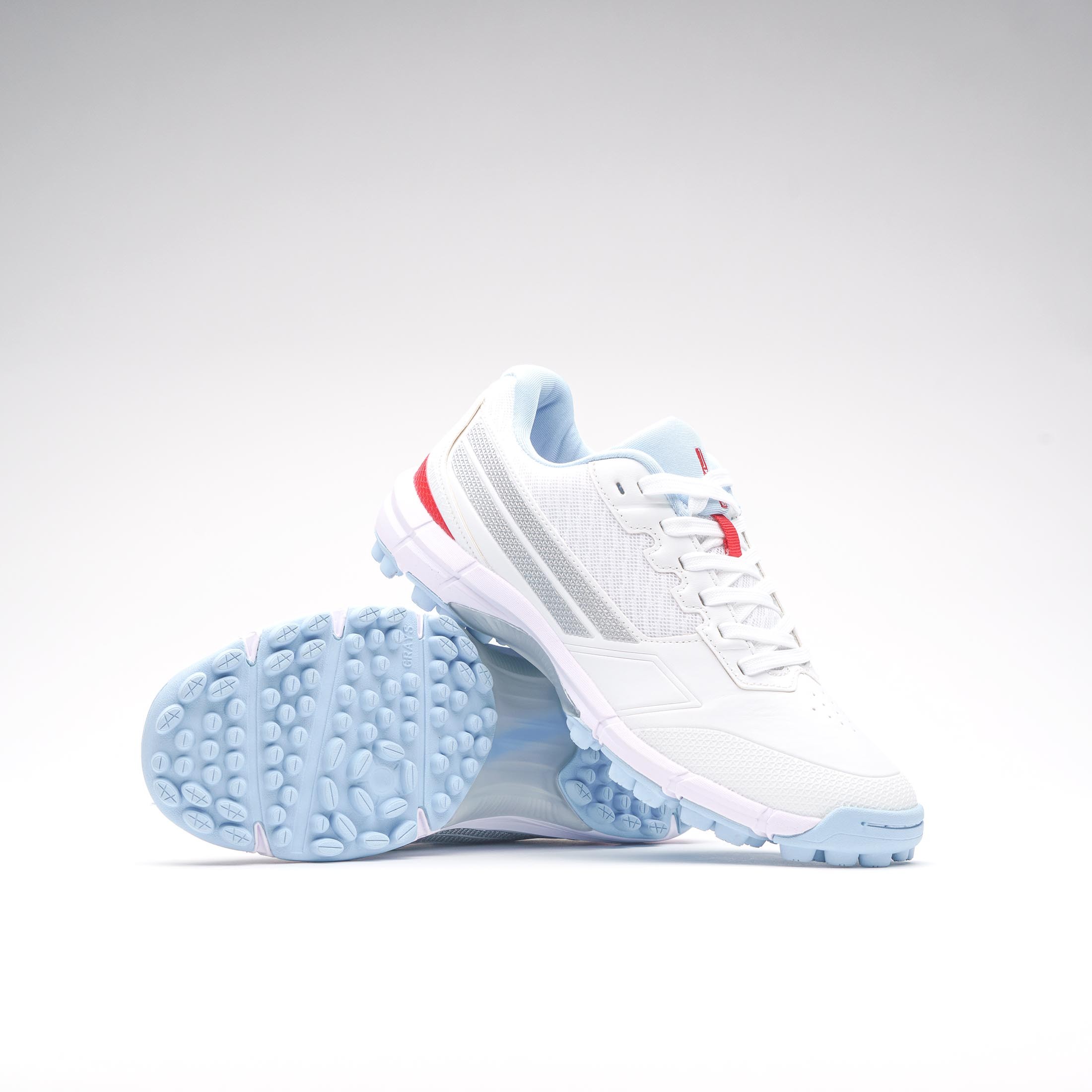 Gray-Nicolls Velocity 5.5 adult batting rubber shoes in white, featuring a sleek design, light blue outsole, and red accents for enhanced style and performance.