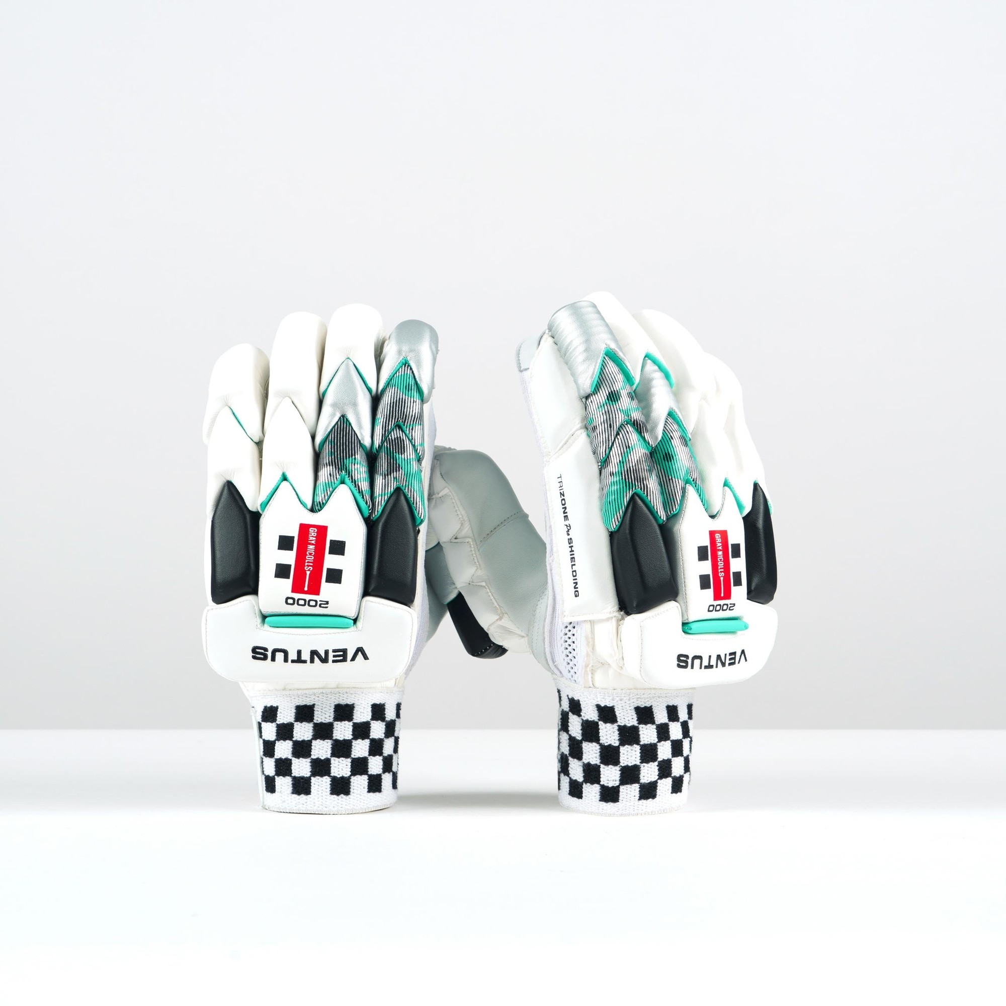 White Gray-Nicolls Ventus 1.0 2000 batting gloves feature a sleek design with green accents, textured palms, and checkered wristbands for enhanced grip and comfort.