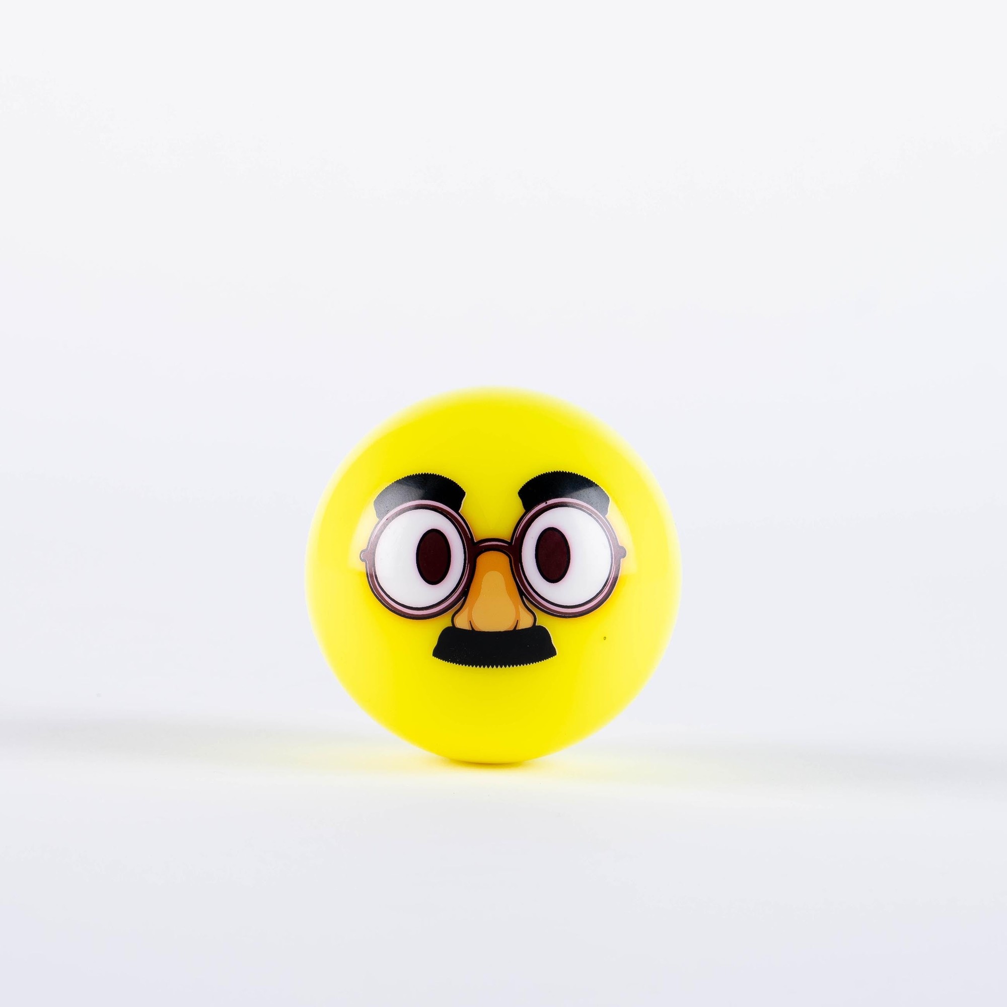 Fluo yellow hockey ball featuring a playful emoji design with large glasses and a mustache, made from durable rubber material.