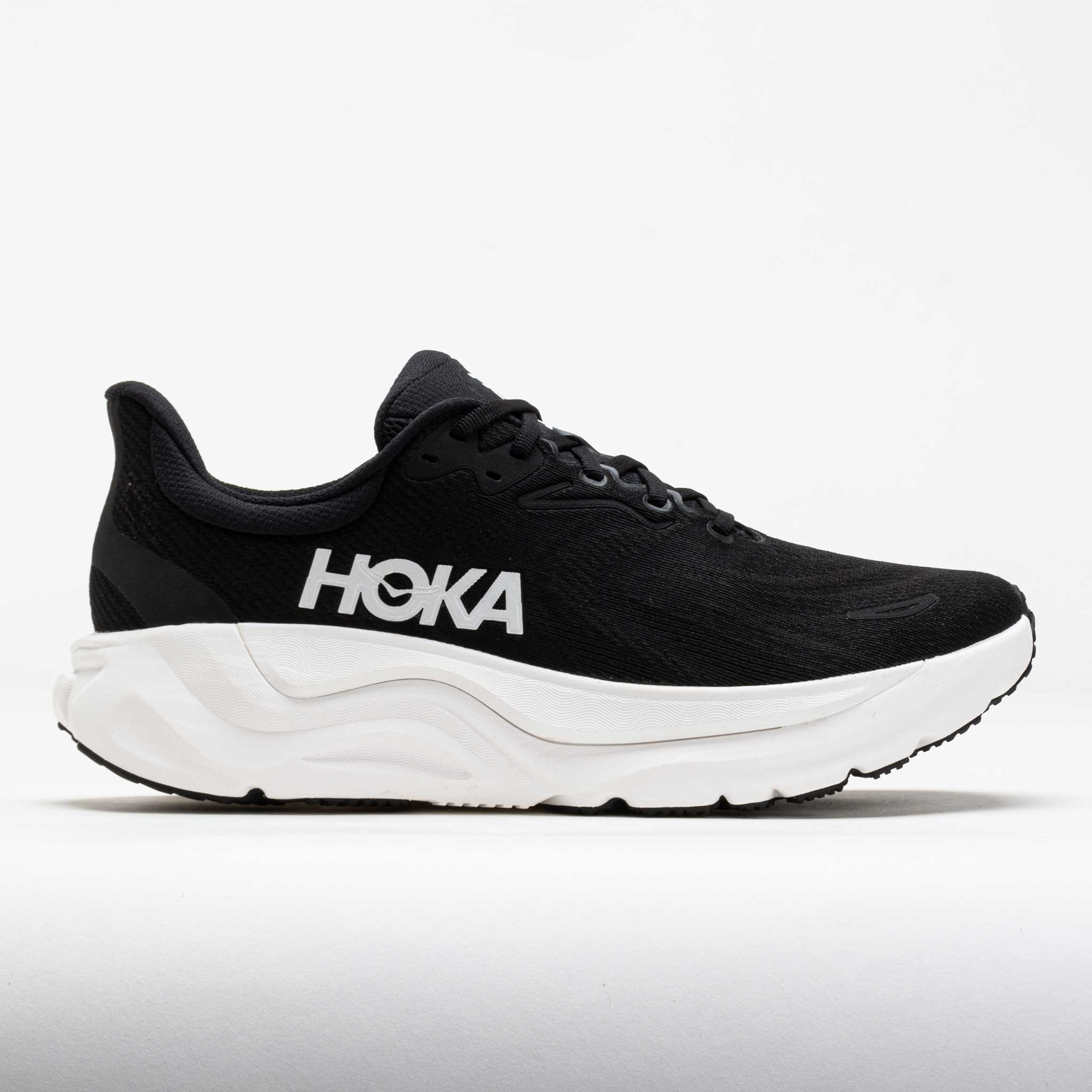 Women's HOKA Arahi 8 running shoes in black and white, featuring a breathable mesh upper, cushioned sole, and prominent HOKA branding on the side.