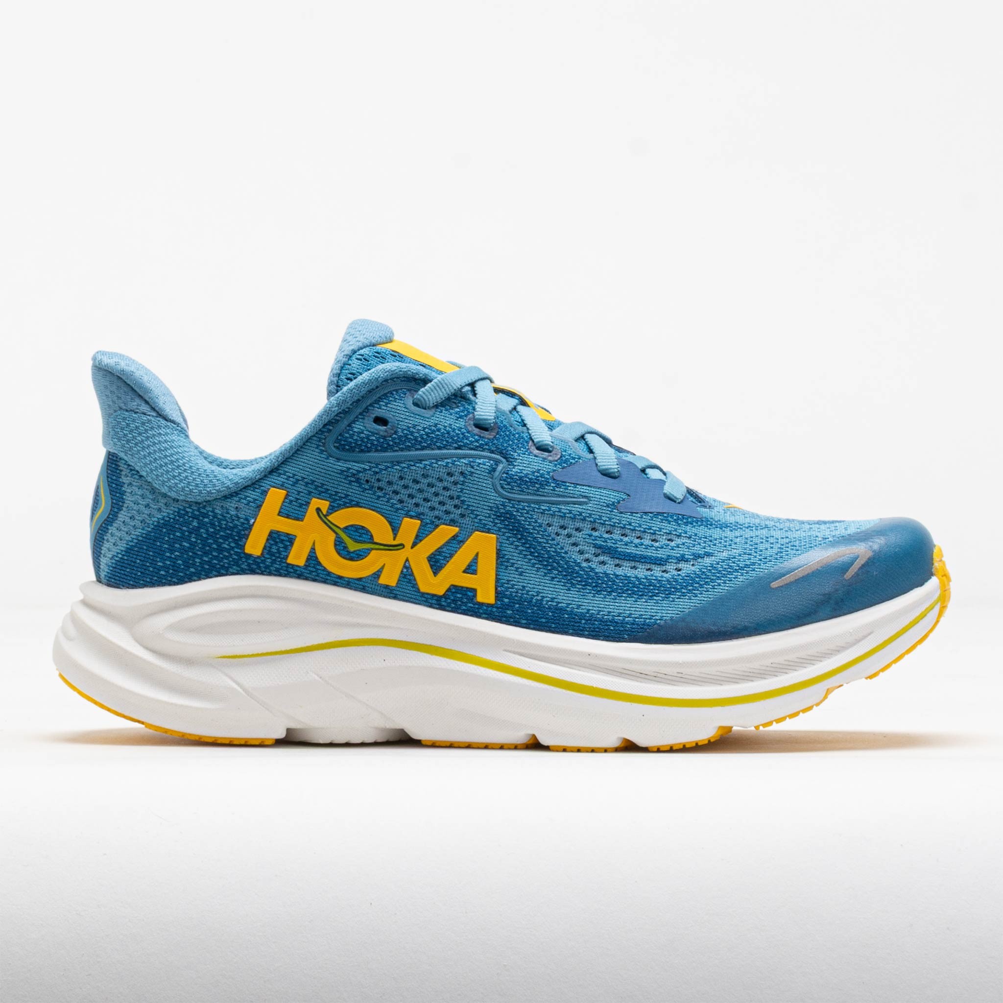 Kids' HOKA Clifton 10 shoes in Alpine Blue and Foggy Night, featuring a breathable mesh upper, cushioned sole, and bold yellow logo on the side.