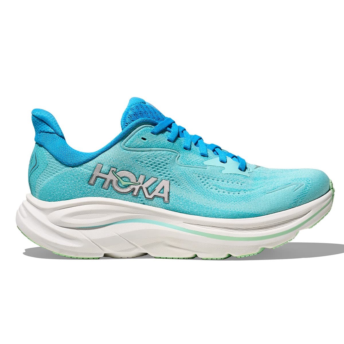 Light blue running shoe with a breathable mesh upper, featuring HOKA branding on the side, a cushioned midsole, and a wide fit, designed for comfort and support.
