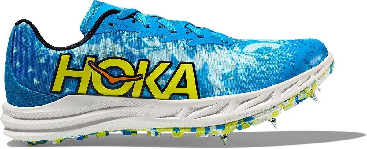 Hoka Crescendo XC unisex shoe in Dive Blue and Evening Primrose, featuring a vibrant blue upper with yellow logo and spikes on the outsole for traction.
