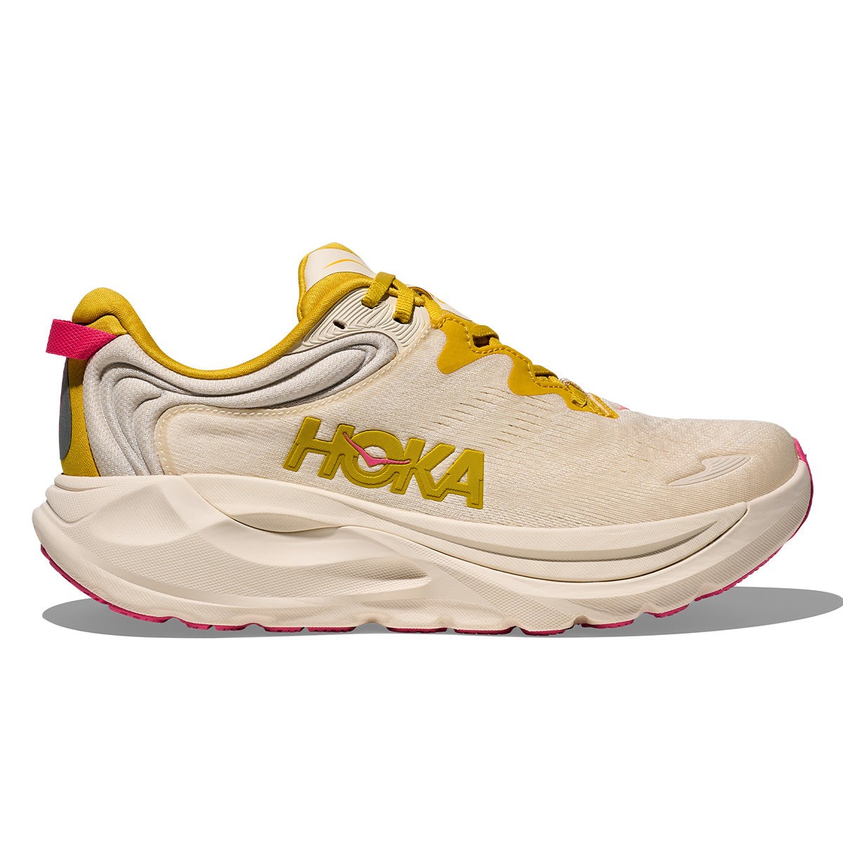 Light bone-colored running shoe with yellow accents, featuring a cushioned sole, breathable upper, and prominent HOKA branding on the side.