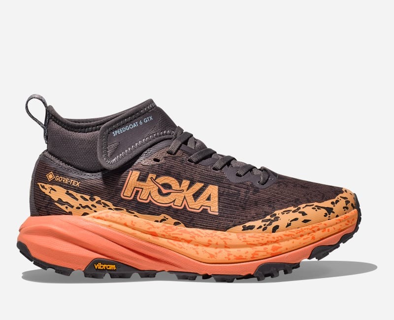 HOKA Women's Speedgoat 6 Mid GORE-TEX Trail Shoes in Galaxy/Guava feature a dark upper with bright orange accents, a high ankle collar, and a rugged sole for trail traction.