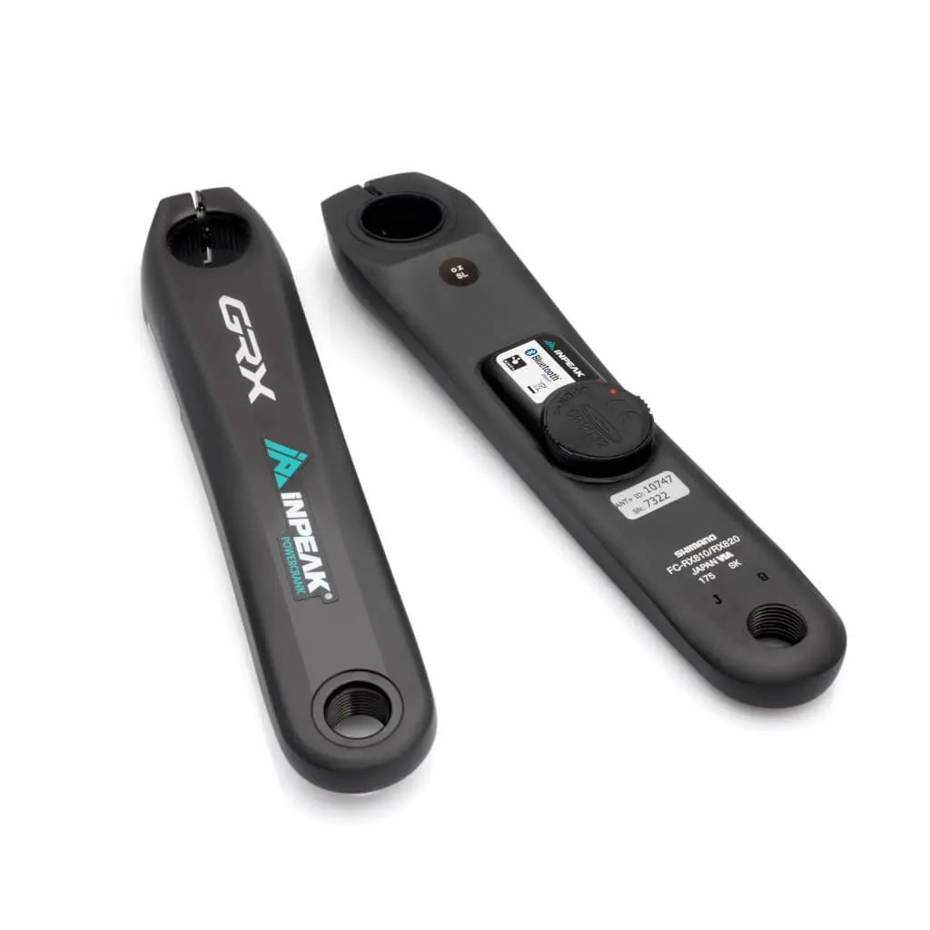 Black power meter crank arms with "GRX" and "INPEAK" logos, featuring a sleek design, a round sensor on one arm, and a display panel with buttons on the other.