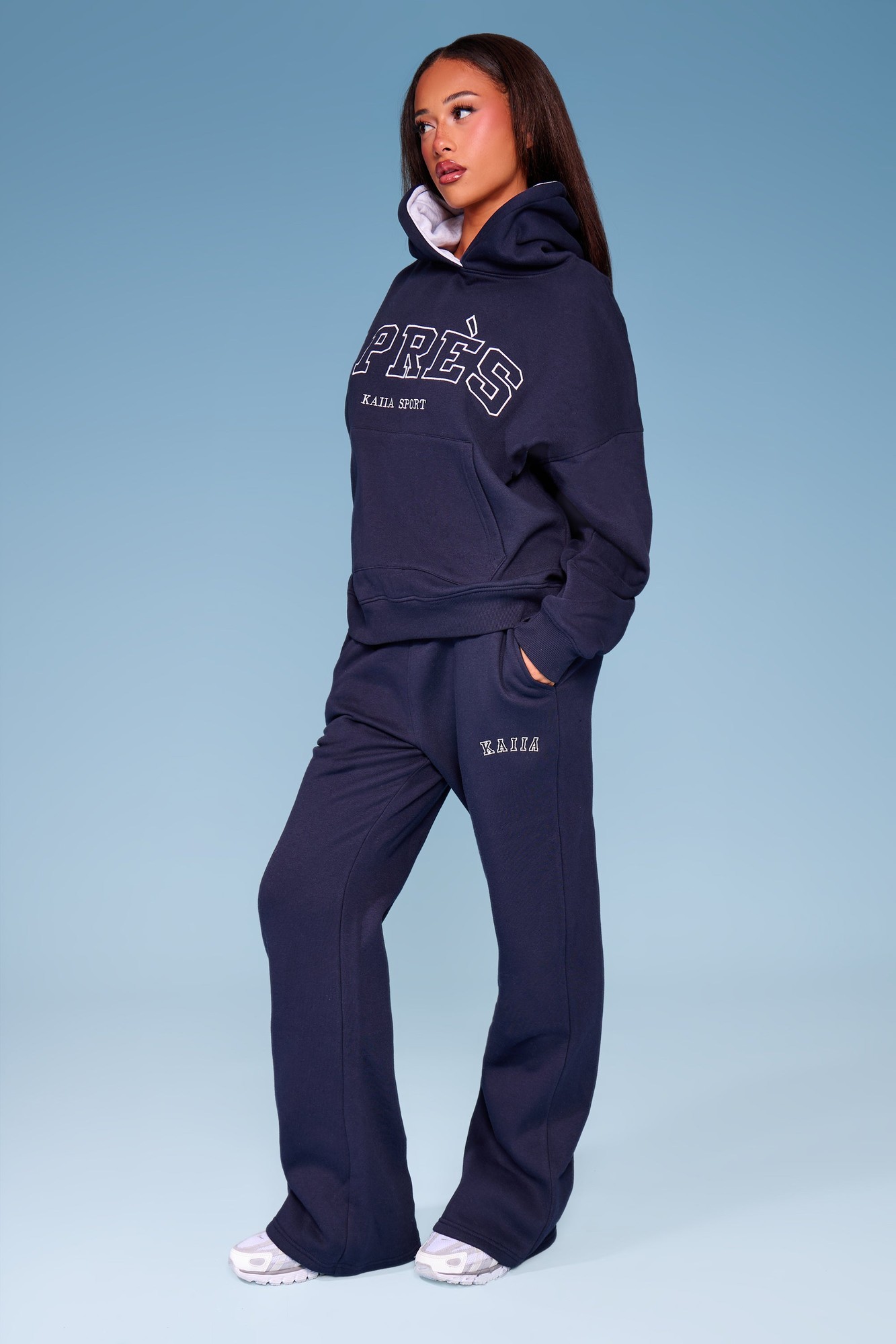 Navy flared joggers made of soft fabric, featuring a comfortable waistband and side pockets, styled with a matching hoodie for a coordinated look.