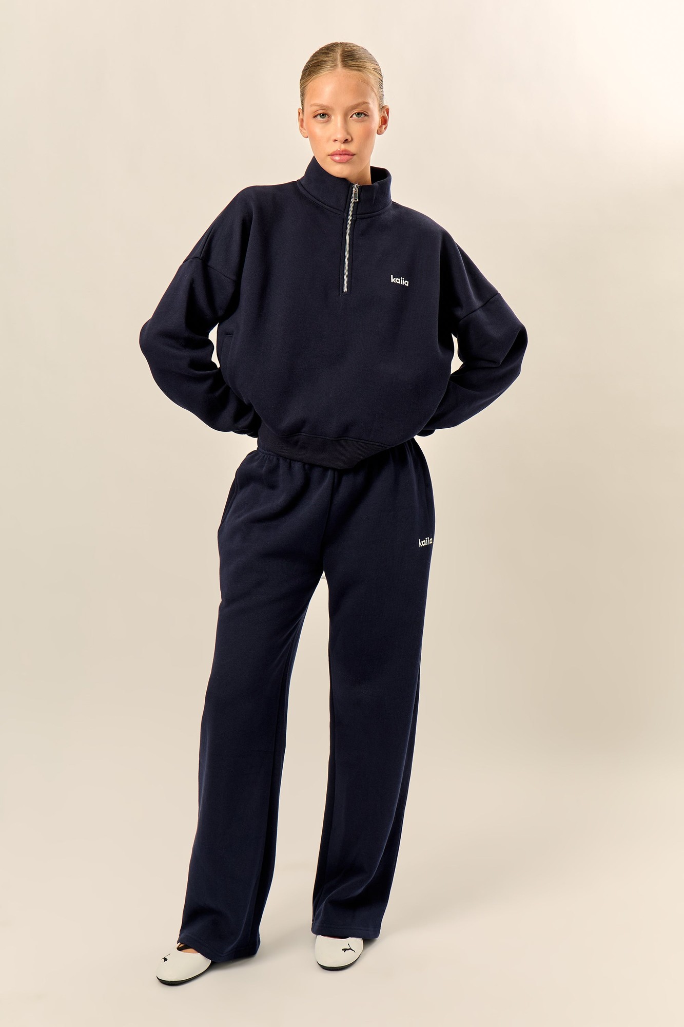 Navy mid-rise wide leg joggers made from soft material, featuring an elastic waistband and subtle Kaiia chrome logo detailing on the left leg.