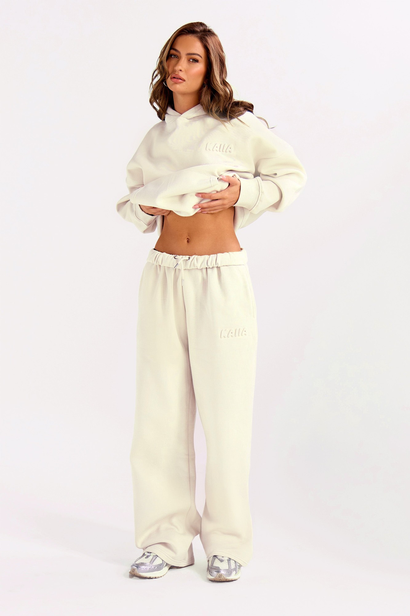 Wide leg joggers in almond milk color, featuring an embossed bubble logo, made from soft material, paired with a matching cropped sweatshirt.