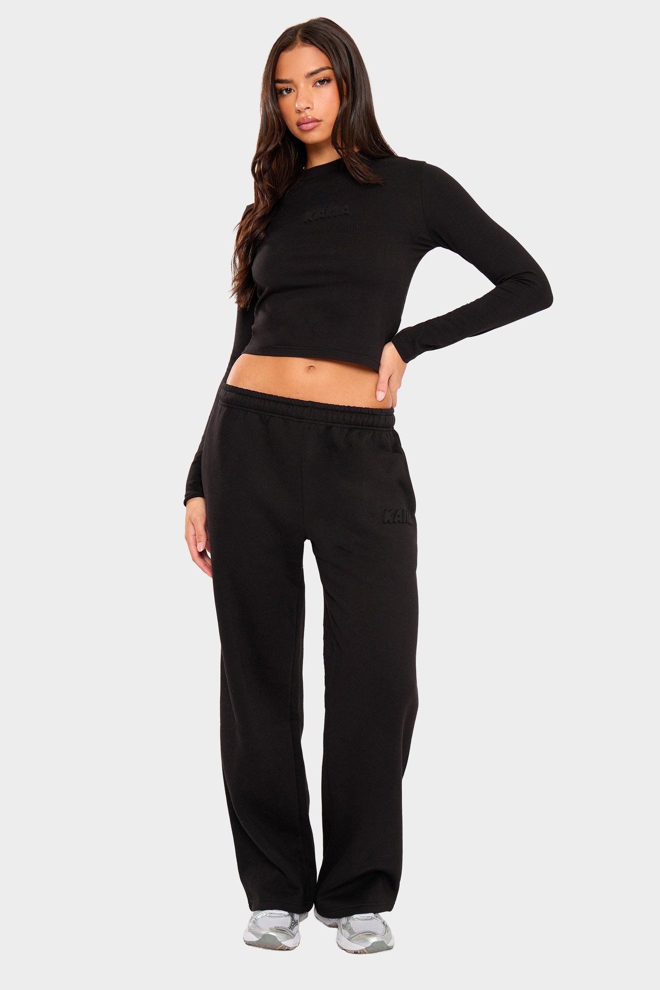 Black wide leg joggers with an embossed bubble logo, featuring a comfortable elastic waistband and a relaxed fit, styled with a matching cropped top.