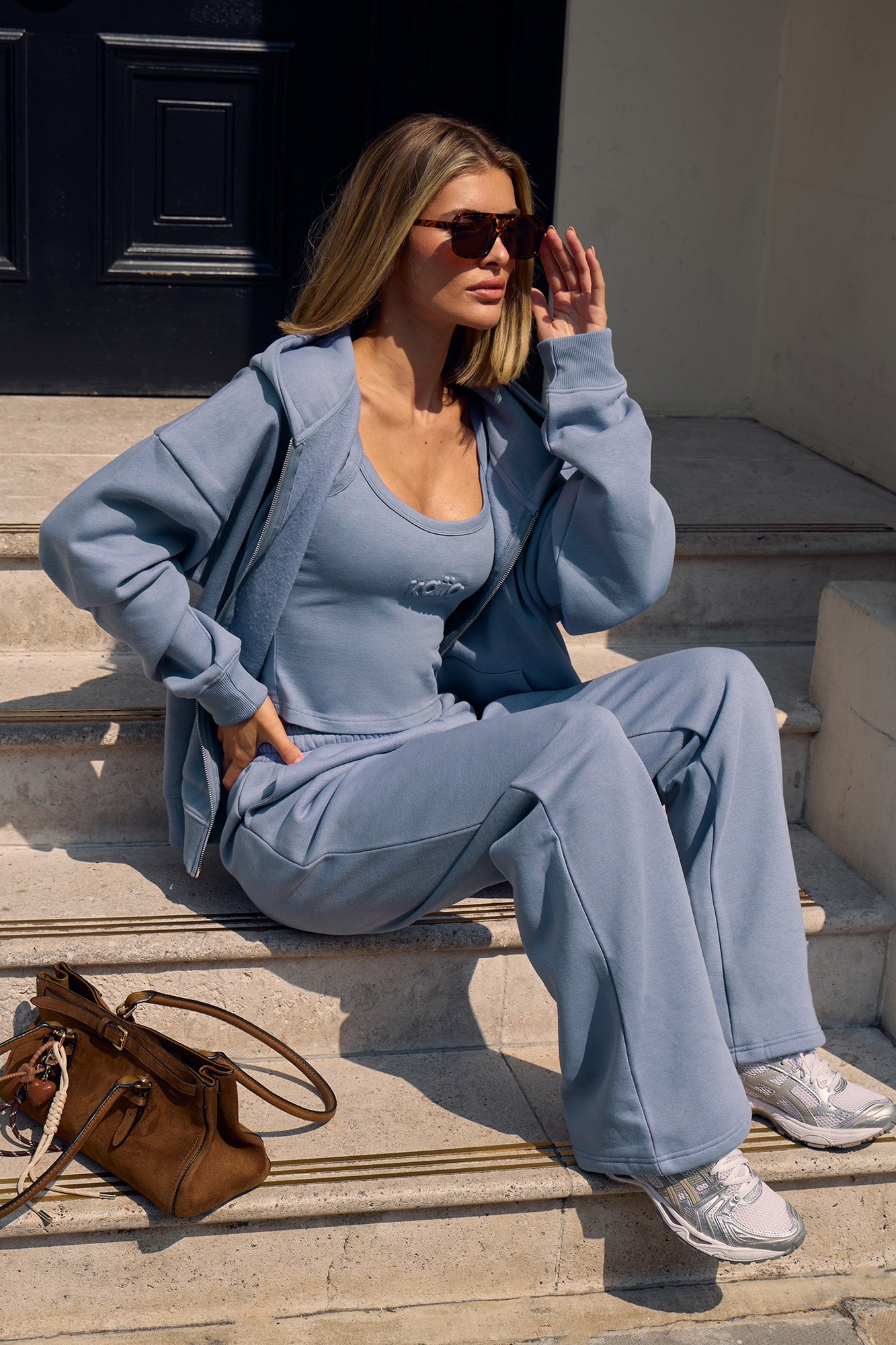 Vintage blue wide-leg joggers made from soft, embossed fabric, featuring an elastic waistband, paired with a matching top and a stylish zip-up hoodie.