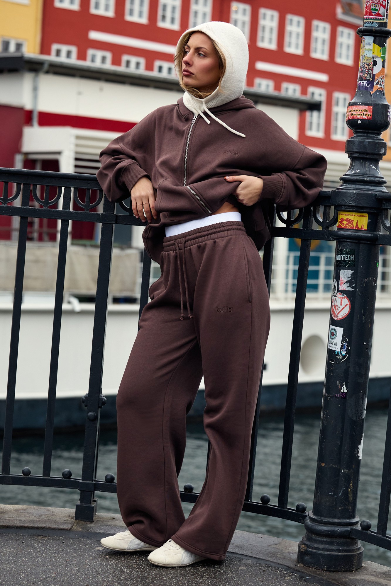 High-waisted joggers in bitter chocolate with a double waistband, featuring a relaxed fit and soft material, styled with a matching hoodie and light-colored shoes.