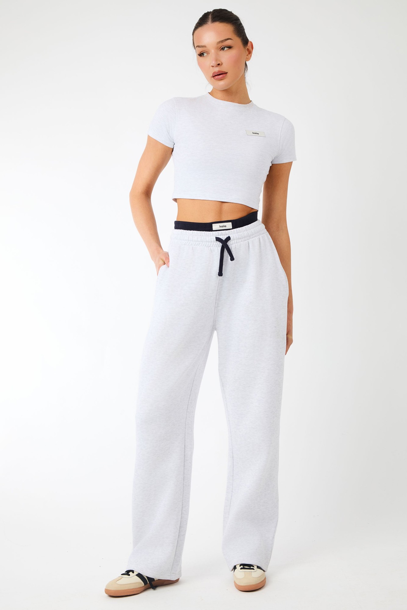 Light grey marl wide leg joggers with an exposed waistband featuring a black drawstring, paired with a matching cropped t-shirt, showcasing a casual and stylish look.