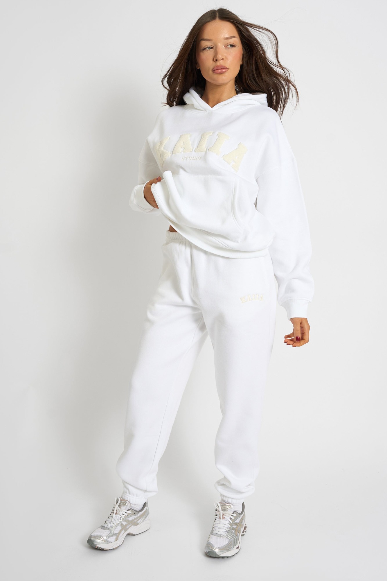 Cream cuffed joggers made from soft material, featuring an elastic waistband and the "Kaiia" logo embroidered in a subtle, contrasting color.