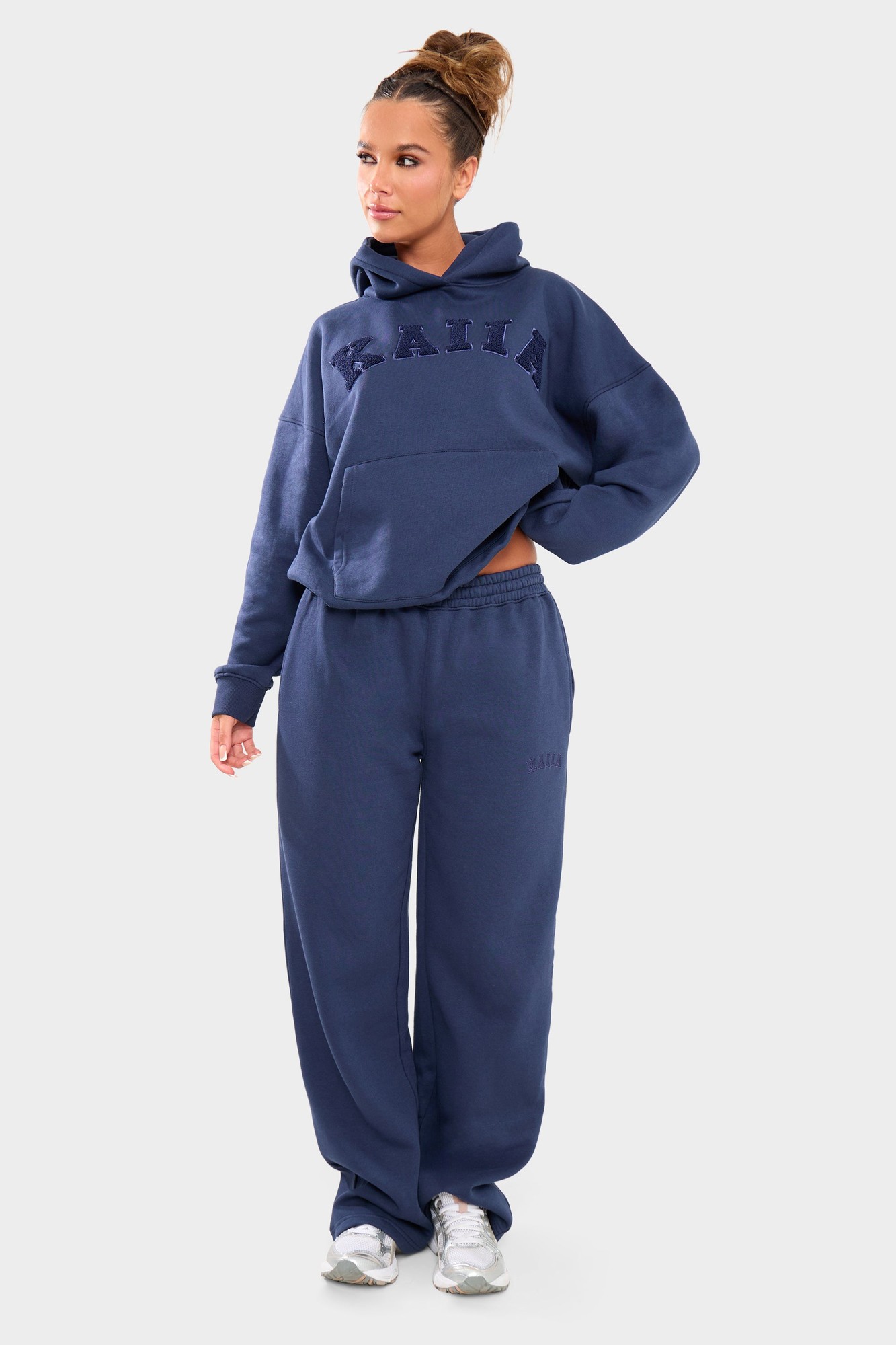 Deep blue wide leg joggers made of soft material, featuring an elastic waistband and subtle branding, paired with a matching hoodie for a coordinated look.