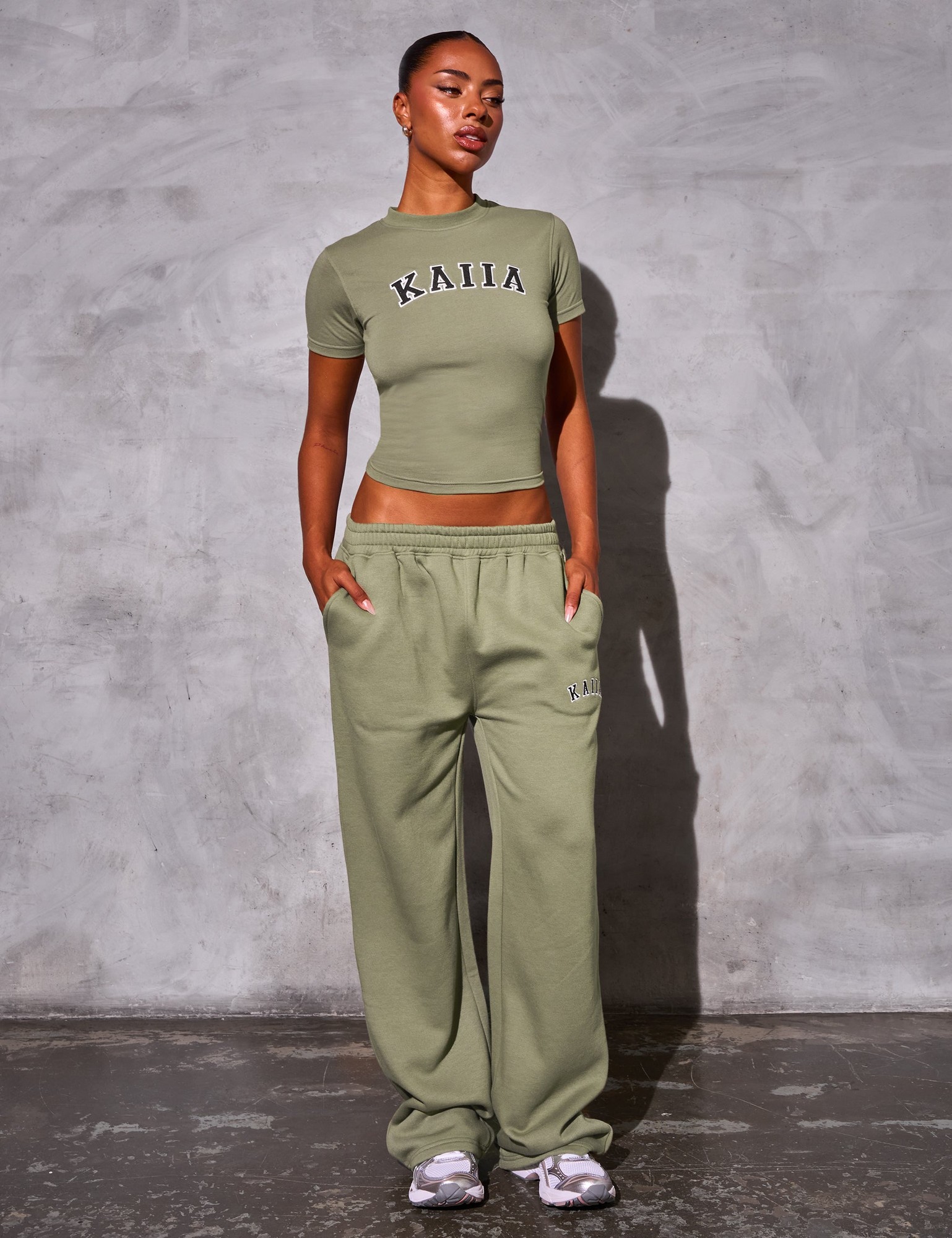 Khaki wide leg joggers made of soft material, featuring an elastic waistband and side pockets, paired with a matching fitted top displaying the "Kaiia" logo.