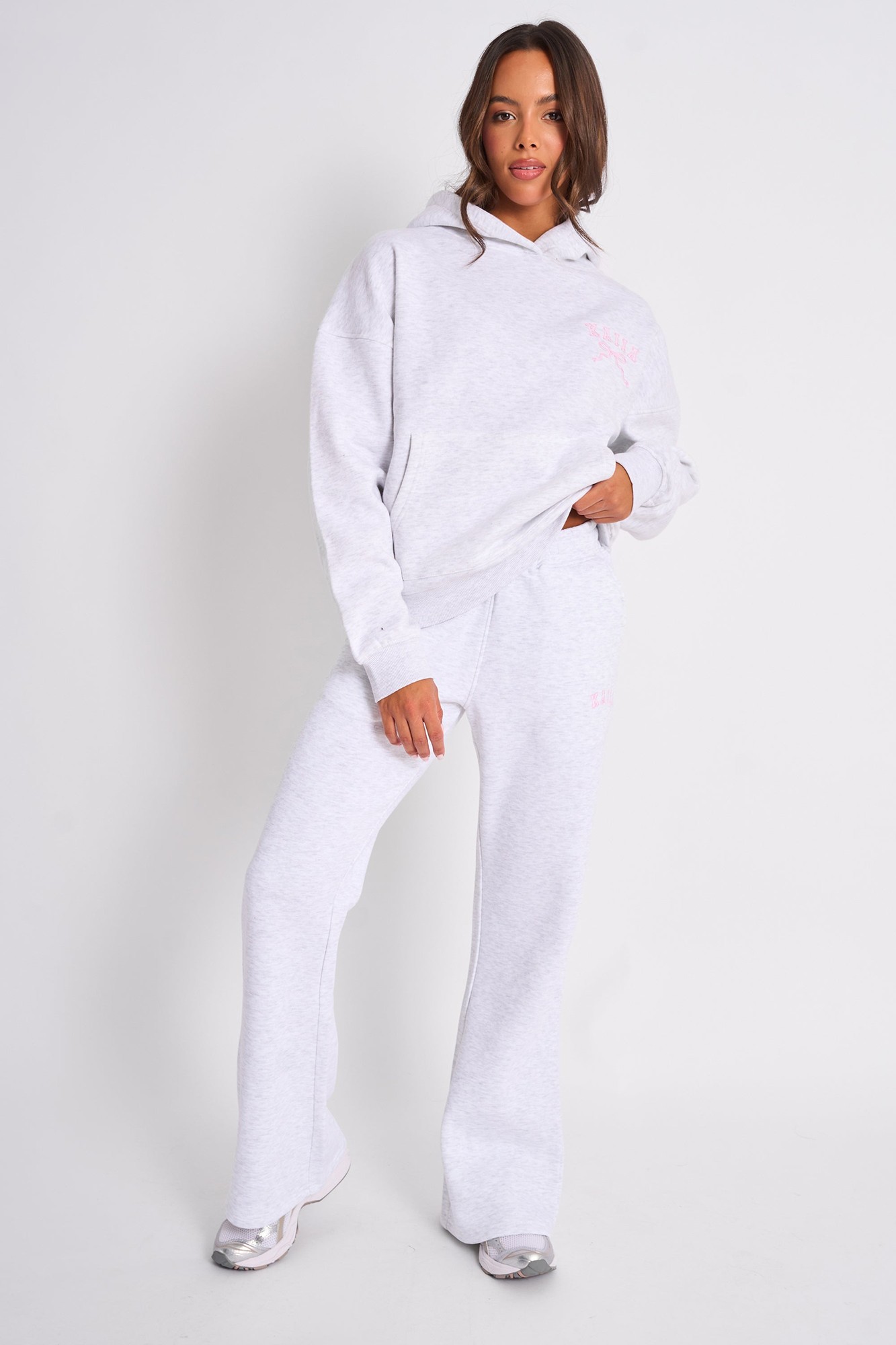 Light grey marl wide leg joggers with a soft, comfortable fabric, featuring a baby pink logo on the left hip, styled with a matching oversized hoodie.
