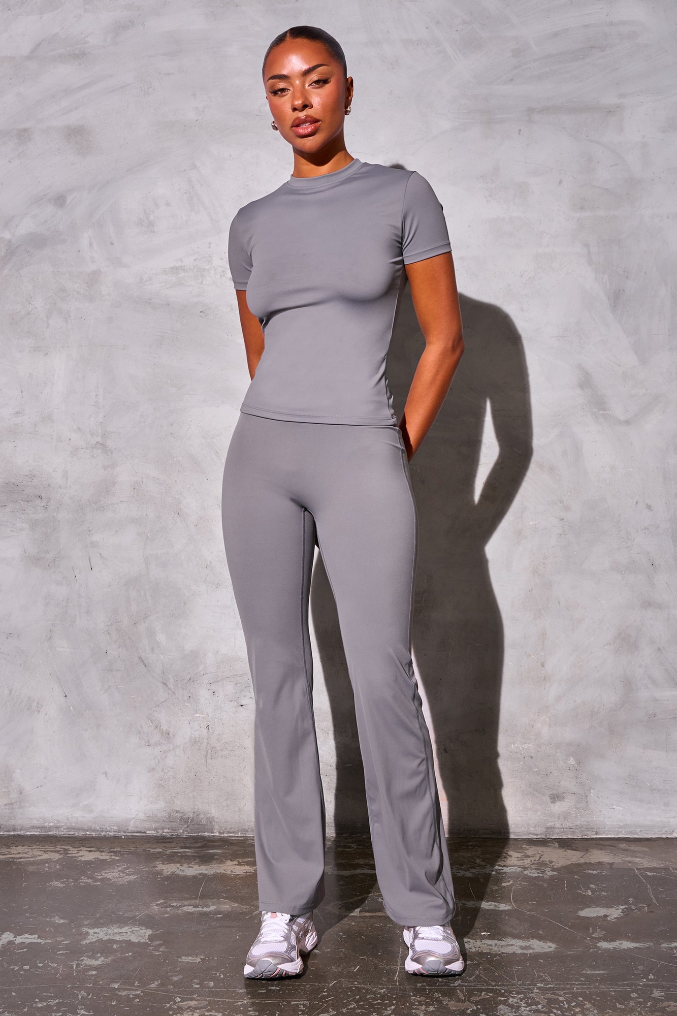 Slate grey sculpt yoga pants made from a stretchy, breathable material, featuring a sleek design and a flattering fit, paired with a matching short-sleeve top.