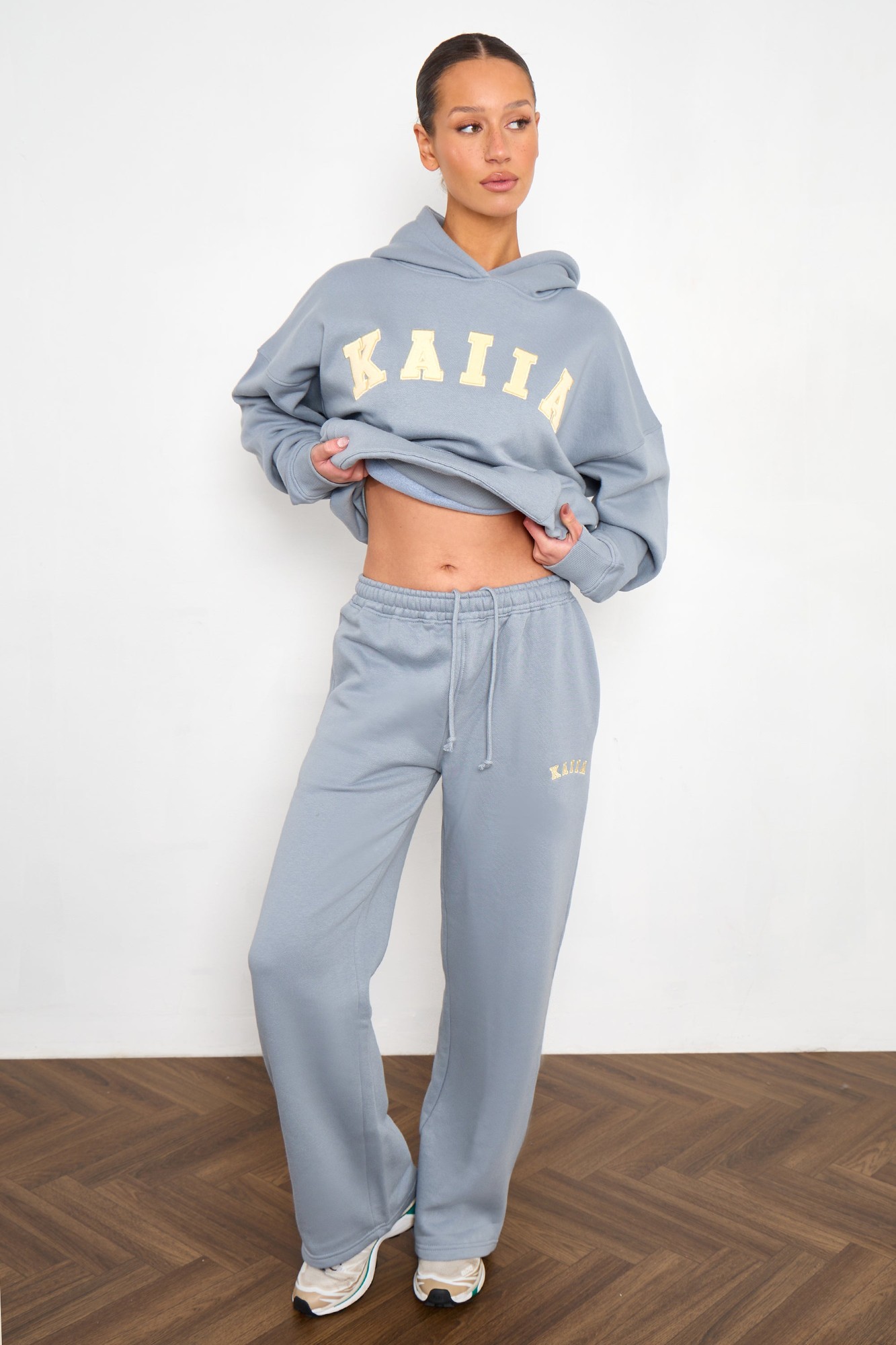 Mist grey wide-leg joggers with a drawstring waist, featuring yellow "KAIIA" slogan embroidery, paired with a matching hoodie for a coordinated look.