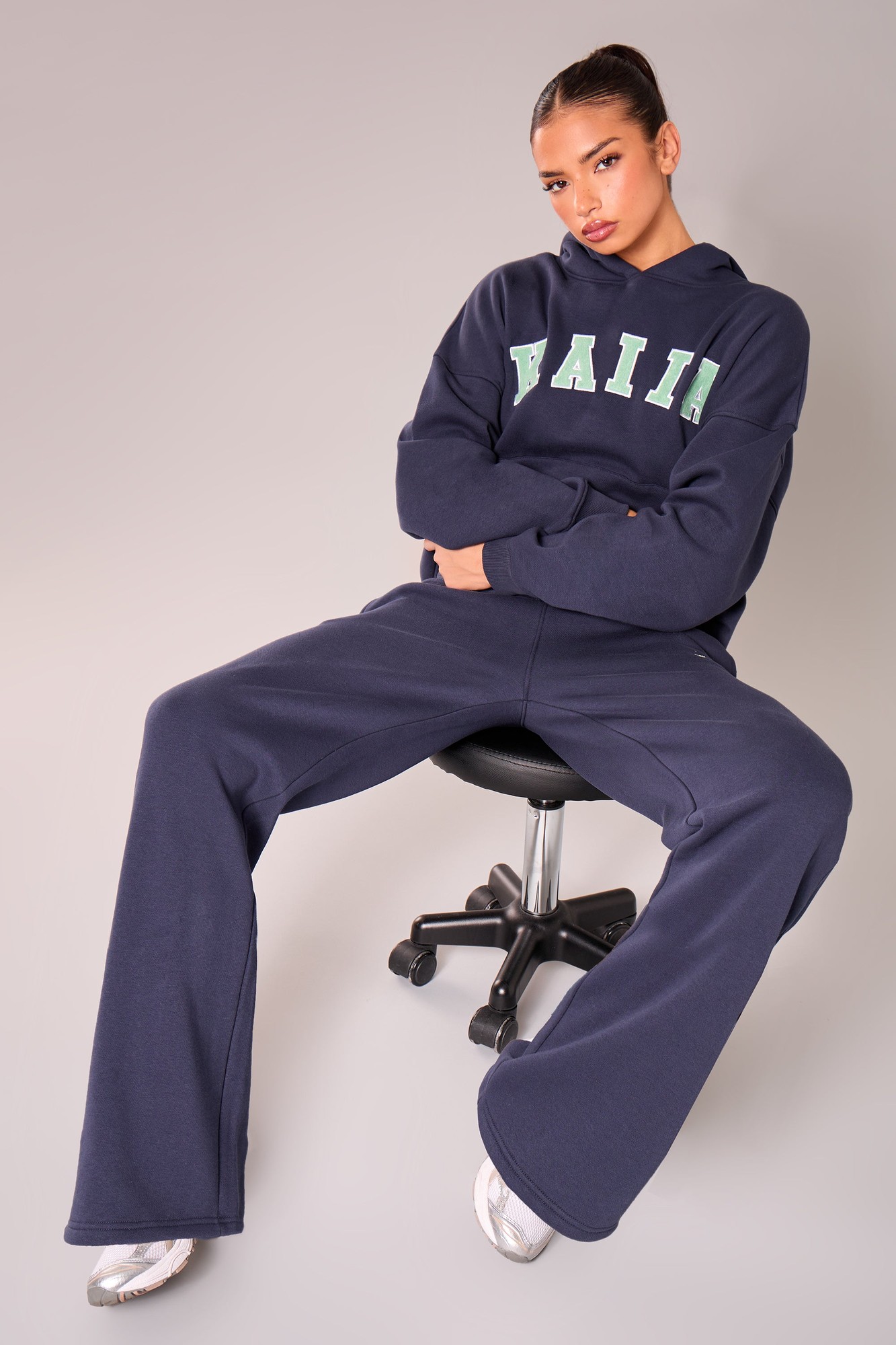 Navy wide leg joggers with jade green "KAIIA" slogan, made of soft material, styled with a matching hoodie, featuring a relaxed fit and comfortable waistband.