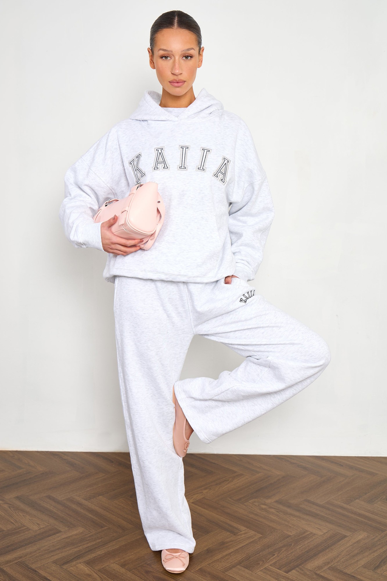 Light grey marl wide leg joggers made from soft material, featuring a comfortable fit and the "Kaiia" slogan embroidered on the front.