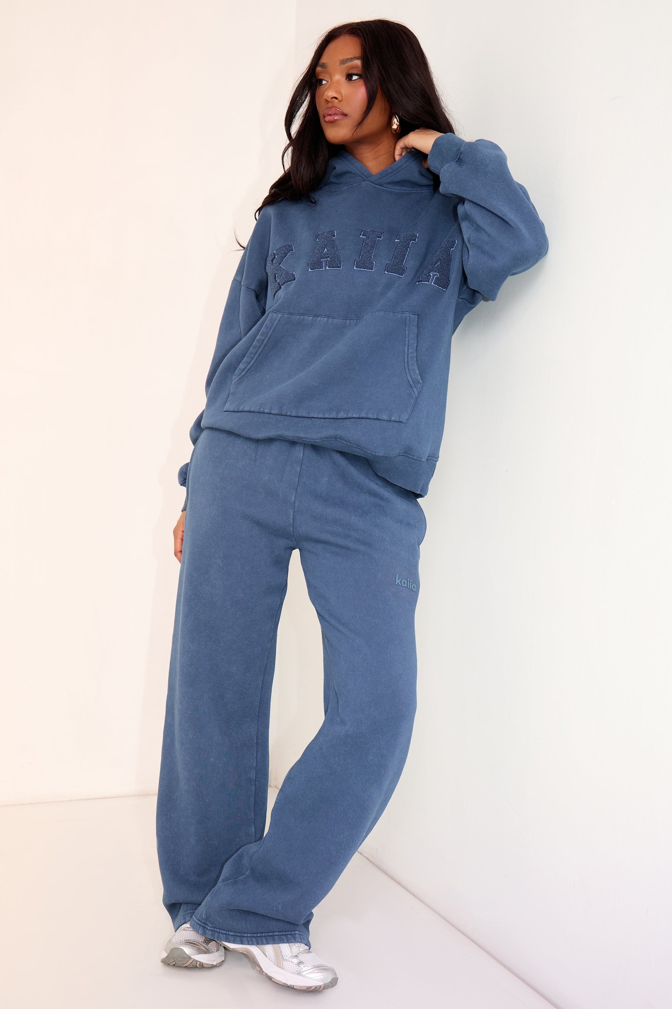 Wide leg joggers in washed petrol color, made from soft material, featuring an elastic waistband and relaxed fit, paired with a matching hoodie showcasing the brand name "Kaiia."