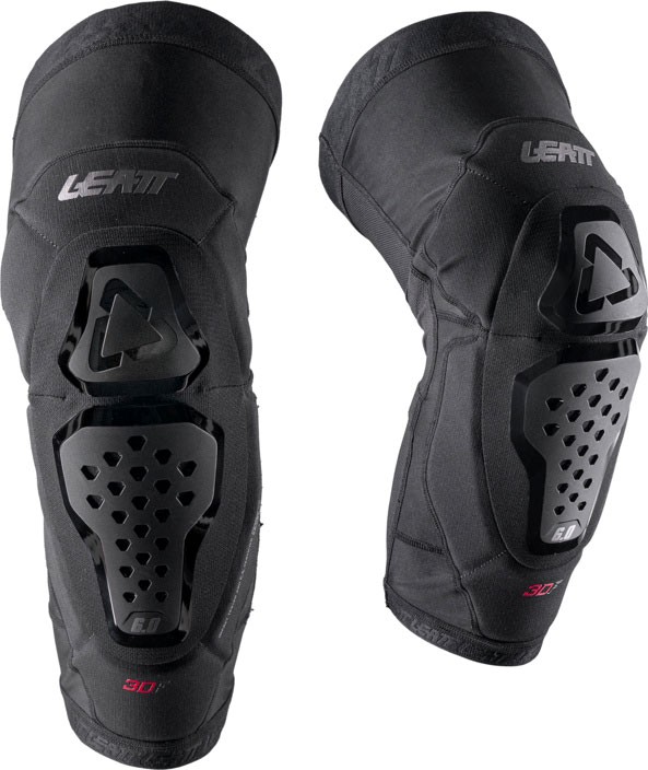 Black Leatt Evo 6.0 knee guards with hard plastic protective shells, ventilation holes, and padded fabric for comfort, designed for enhanced mobility and impact resistance.