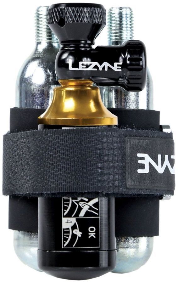 Lezyne CO2 Blaster Inflater in black and gold, featuring a sturdy metal body, a black rubber strap, and two silver 20g CO2 cartridges for tubeless tire repair.