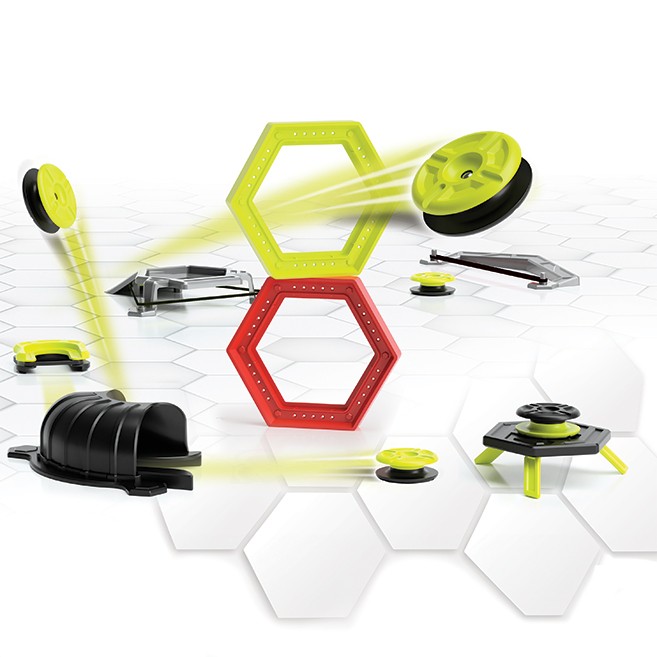 Colorful hexagonal and circular pieces in black, red, and neon yellow, designed for building stunt tracks, with various ramps and launchers on a white hexagonal grid surface.