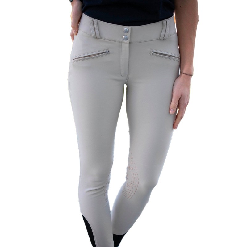Light beige mid-grip competition trousers for women by Pénélope, featuring a sleek design, zippered front pockets, and a stylish fit with textured detailing on the legs.